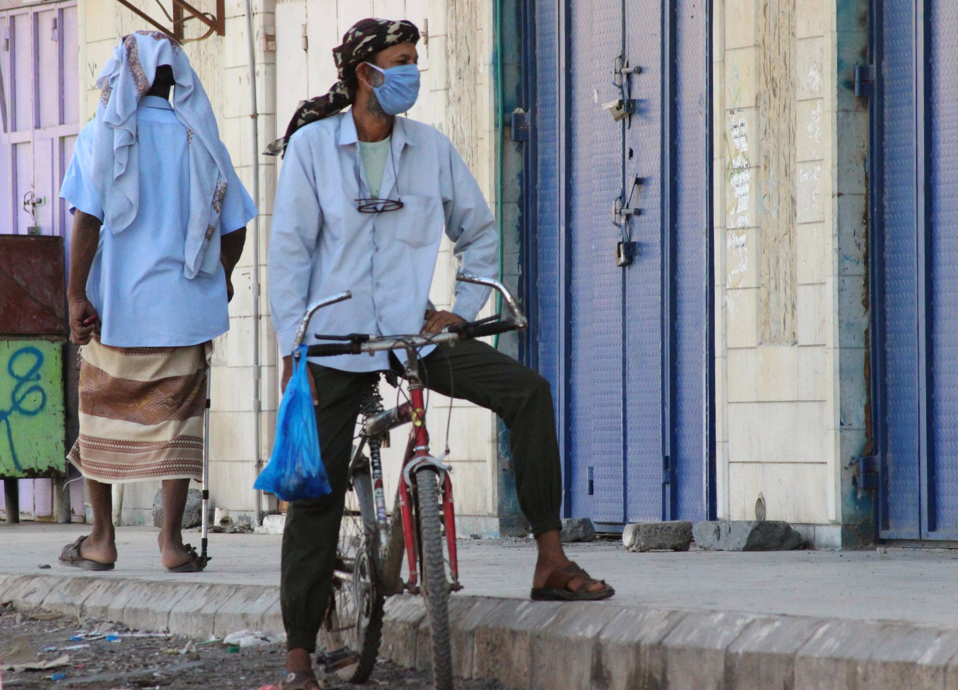 A man wearing a protecitve face mask rides a bicycle during a curfew amid concerns about the spread of the coronavirus disease (COVID-19) in Aden (Reuters)