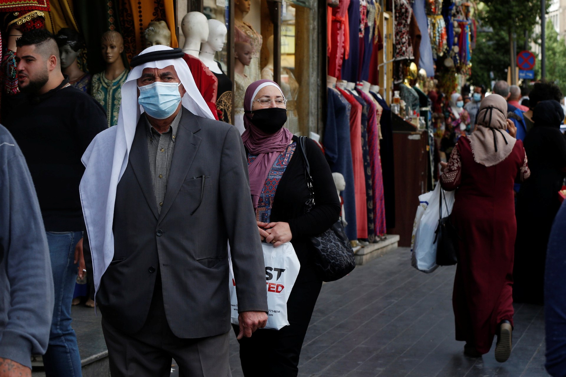 People, some wearing protective masks, walk in downtown Amman, amid fears over rising numbers of the coronavirus disease (Reuters)