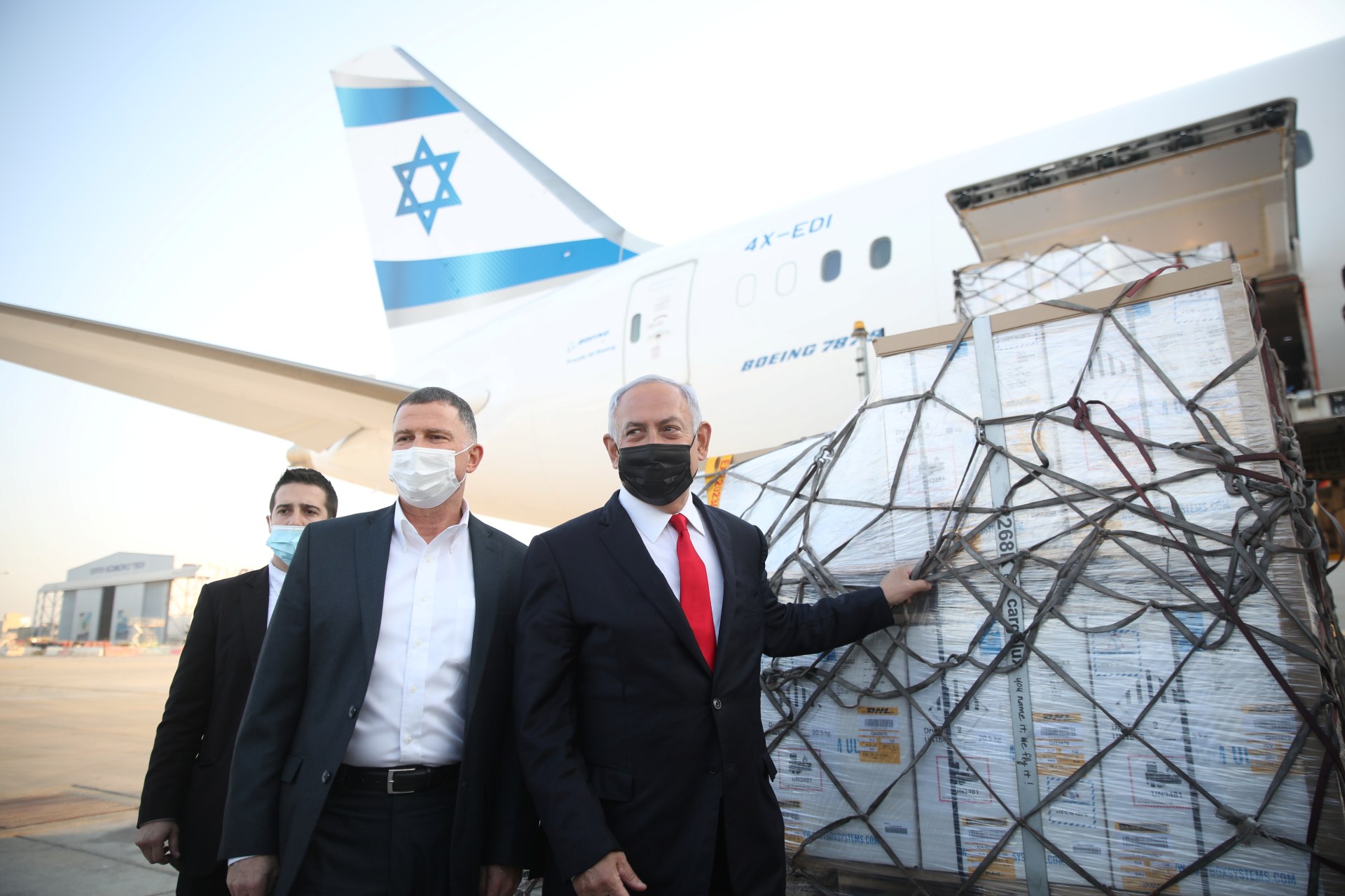 Benjamin Netanyahu and Health Minister Yuli Edelstein attend the arrival of a plane with a shipment of Pfizer-BioNTech coronavirus disease (COVID-19) vaccines, at Ben Gurion airport (Reuters)