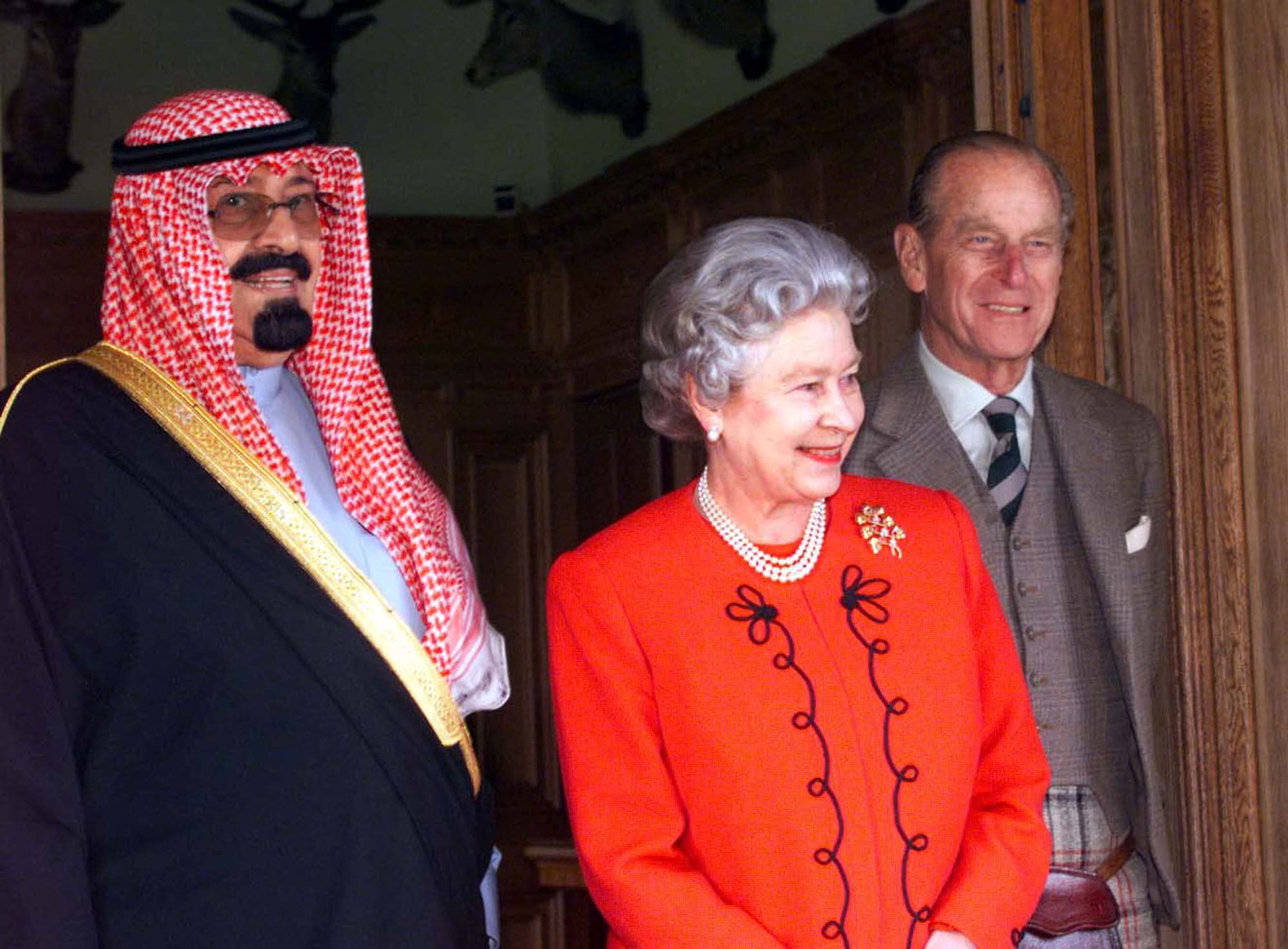 La reine et le duc d’Édimbourg se tiennent aux côtés du prince héritier d’Arabie saoudite, le prince Abdallah ben Abdelaziz al-Saoud (à gauche) après un déjeuner au château de Balmoral en septembre 1998 (AFP)