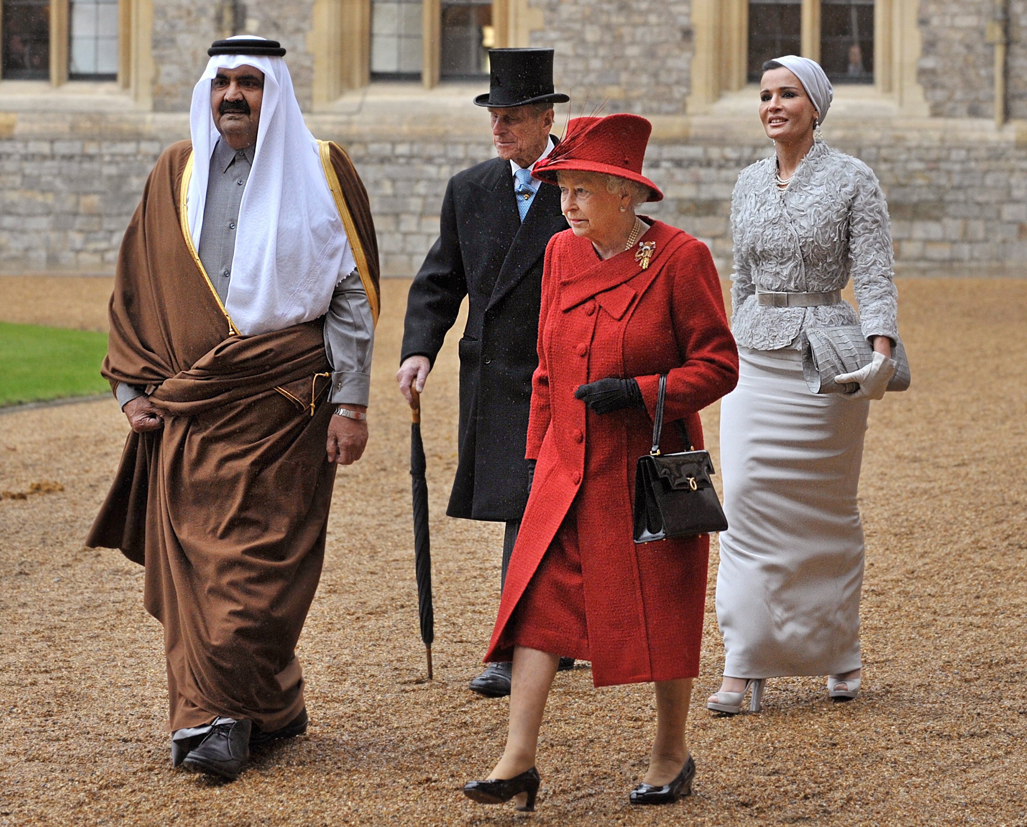 L’ancien émir du Qatar, le cheikh Hamad ben Khalifa al-Thani et son épouse Mozah marchent avec la reine Elizabeth II et son mari le prince Philip au château de Windsor en octobre 2010 (AFP)