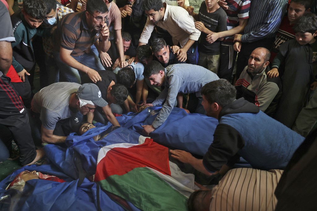 Des Palestiniens pleurent les victimes des frappes aériennes israéliennes, à Jabaliya, dans le nord de la bande de Gaza, le 11 mai (AFP)