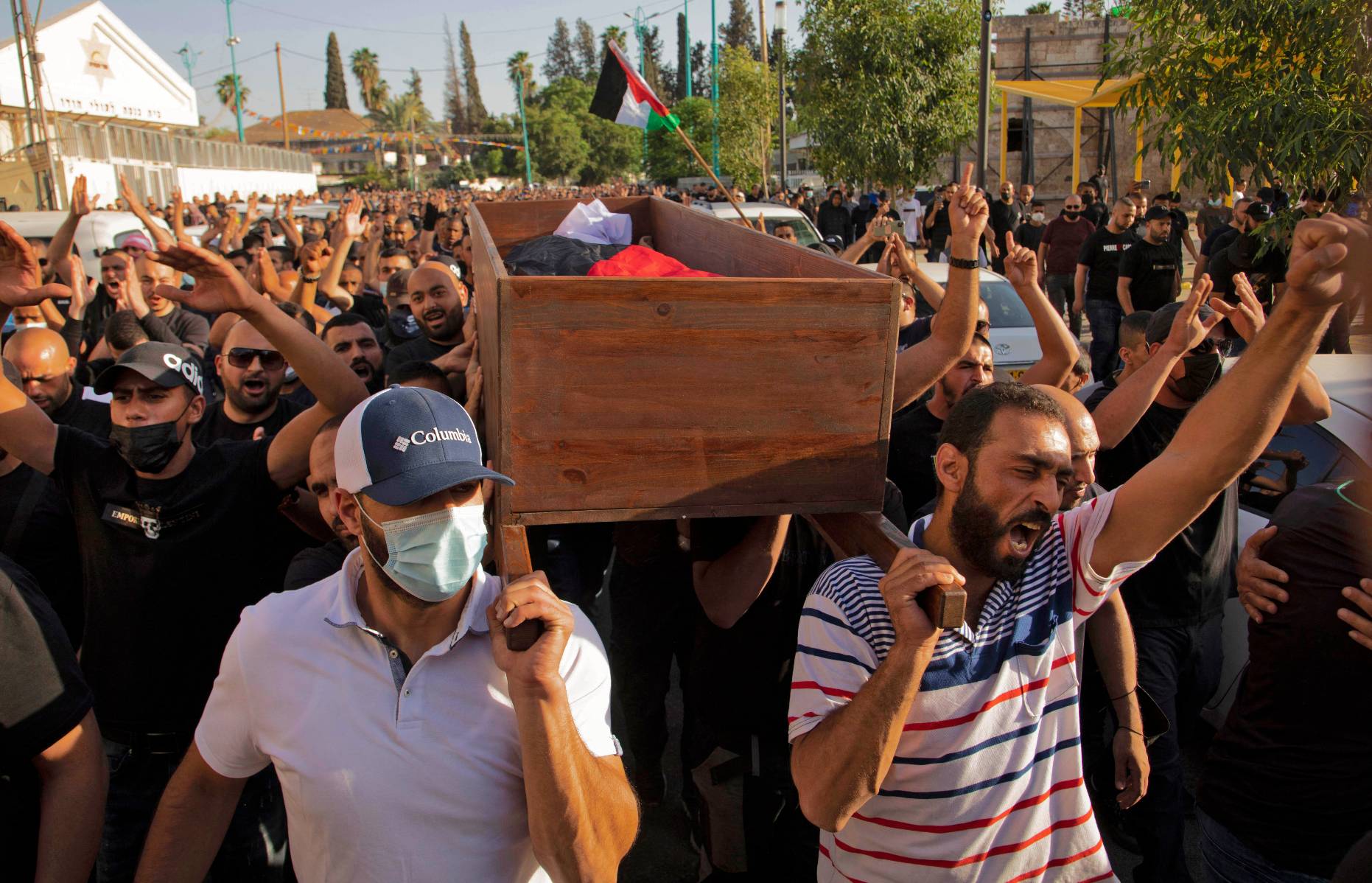 Palestinians carry the coffin of Moussa Hassouna in Lod on 11 May 2021 (AFP)
