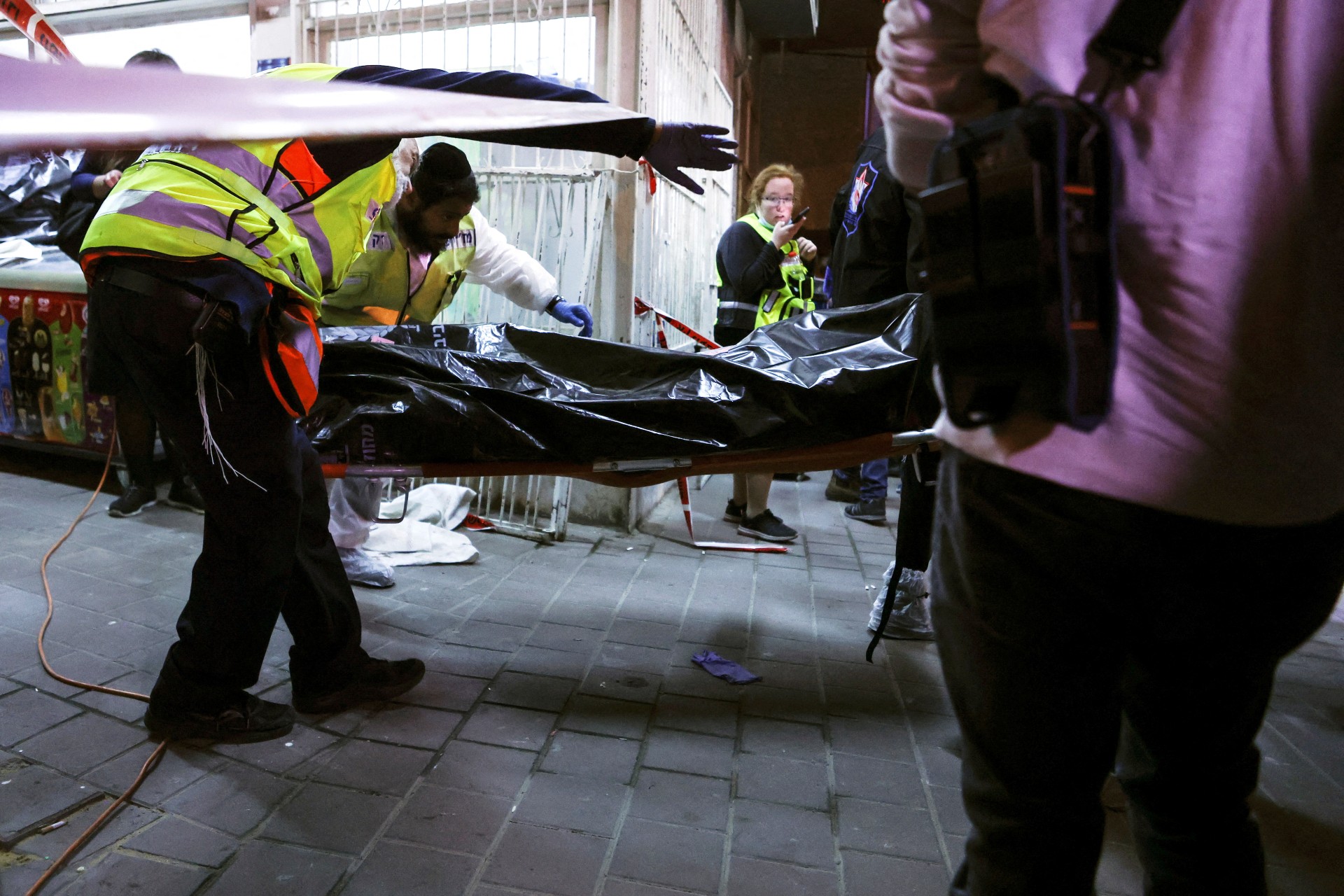 Israeli medical personnel and rescue workers evacuate a body from the scene of a fatal shooting attack on a street in Bnei Brak (Reuters)
