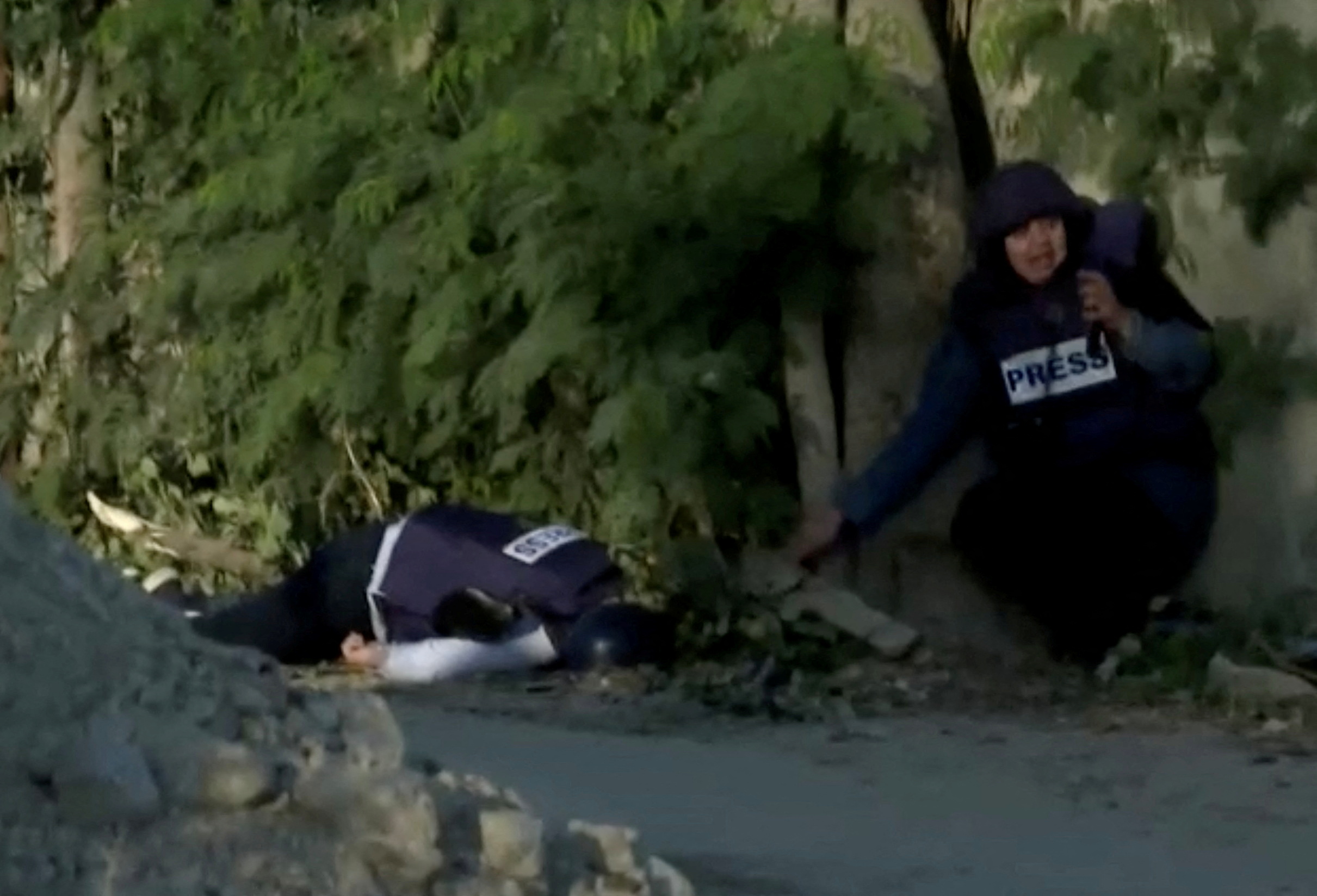 Shatha Hanaysha is seen next to the dead body of Al Jazeera journalist Shireen Abu Akleh in Jenin (Reuters)