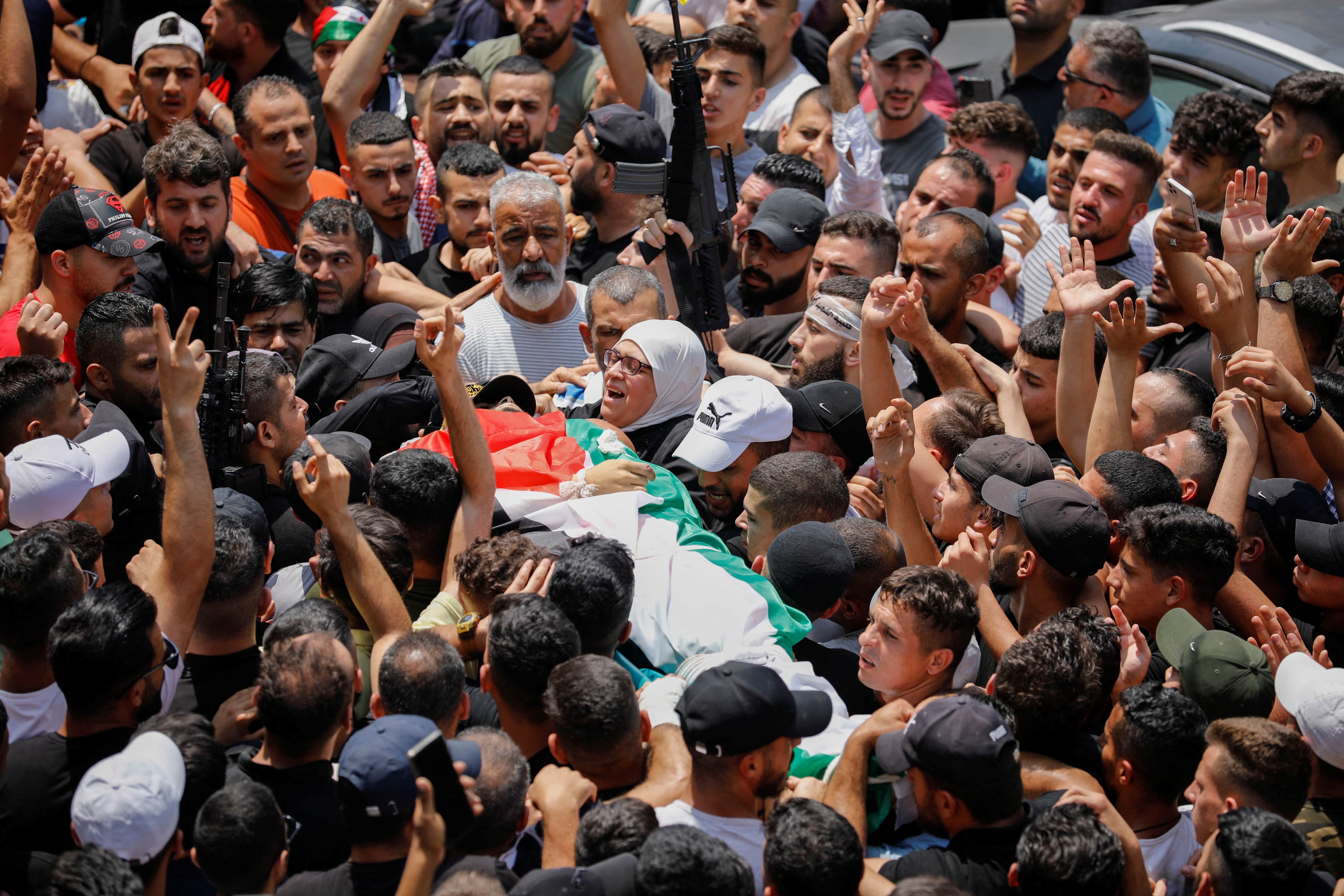 Mourners carry the body of Ibrahim al-Nabulsi who was killed by Israeli forces, during a funeral in Nablus in the Israeli-occupied West Bank 9 August 2022 (Reuters)