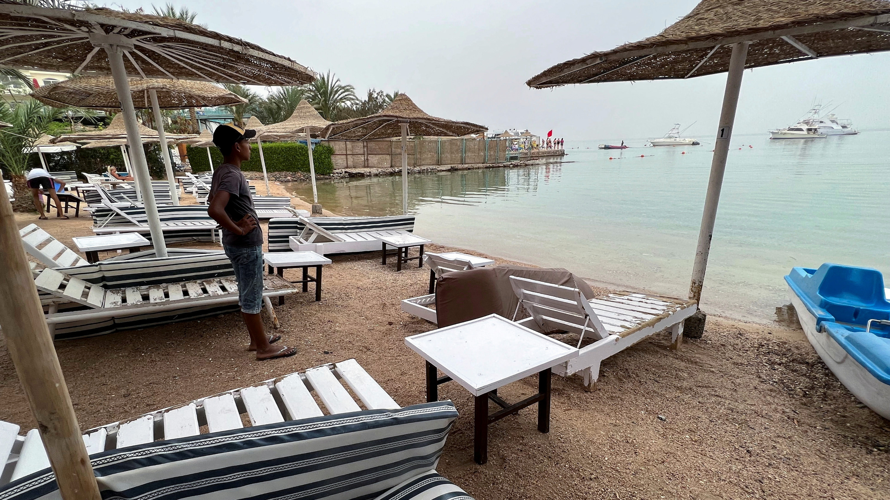 A worker stands on a beach closed after a Russian citizen was killed in a shark attack near the Egyptian Red Sea resort of Hurghada, 9 June 2023 (Reuters)