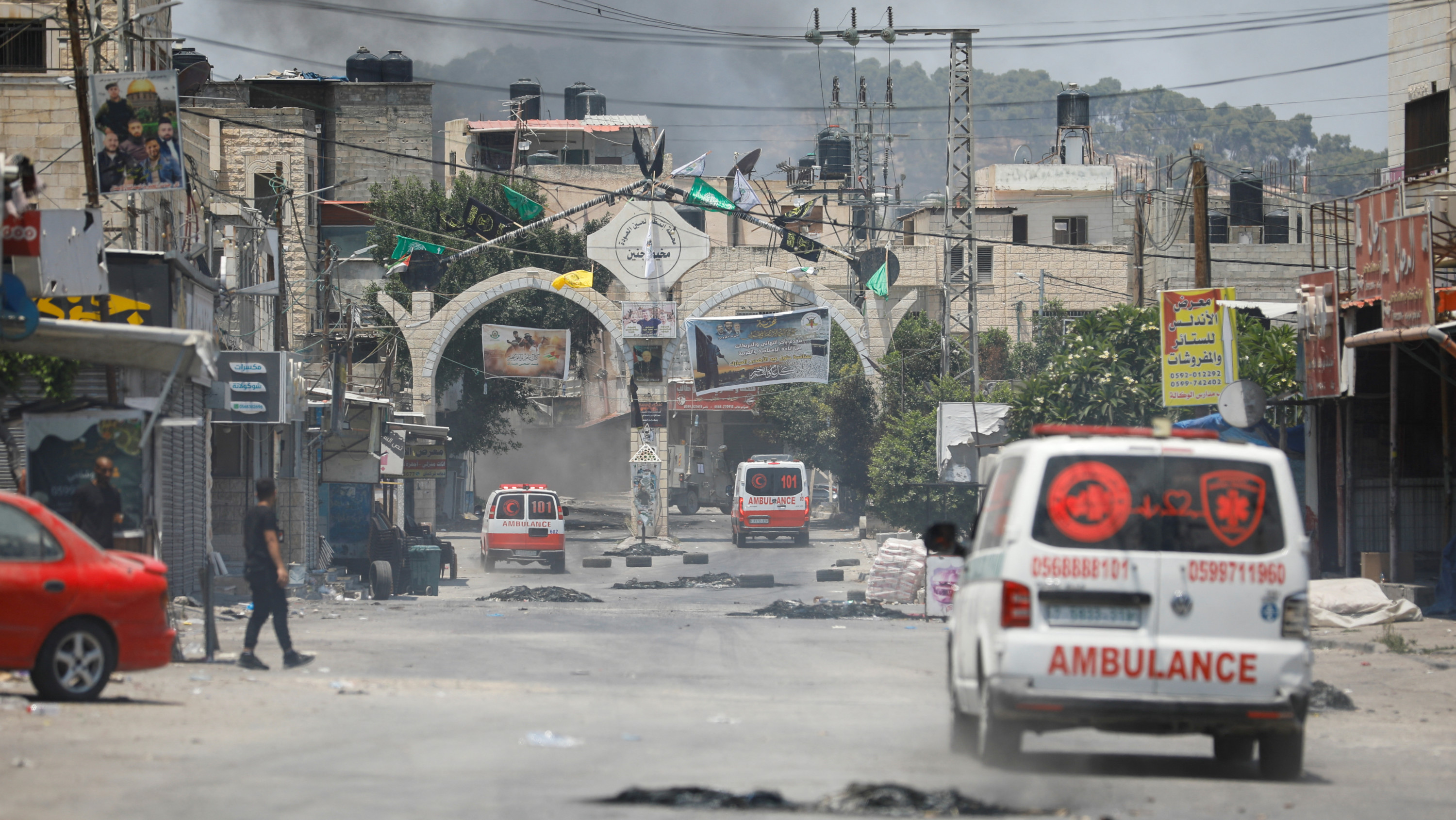 Smoke rises as ambulances drive during an Israeli military operation in Jenin in theoccupied West Bank 3 July 2023 (Reuters)