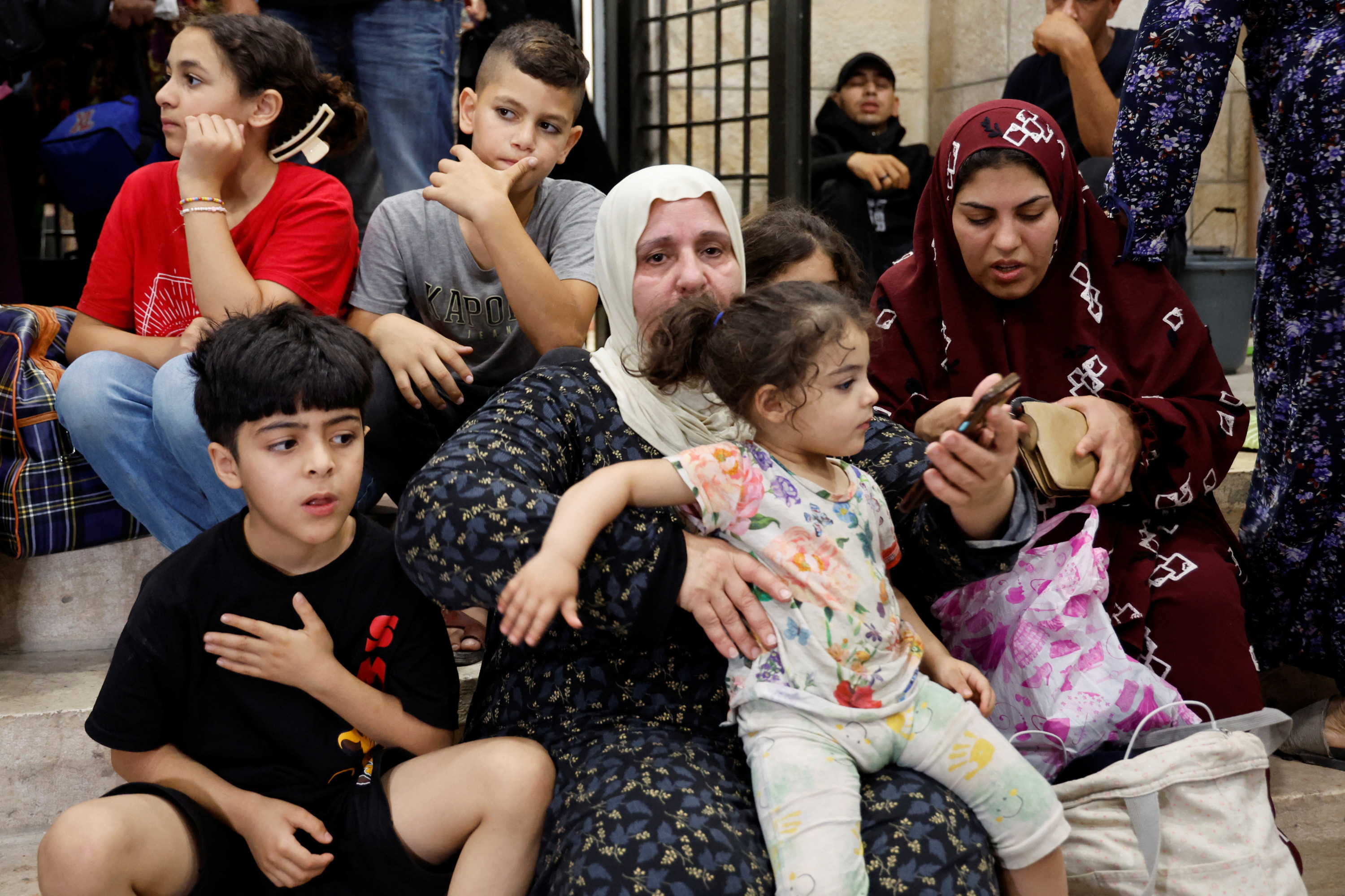 People rest as residents of Jenin camp are forced to flee their homes amid an Israeli military campaign in the occupied West Bank city on 3 July 2023 (Reuters) 