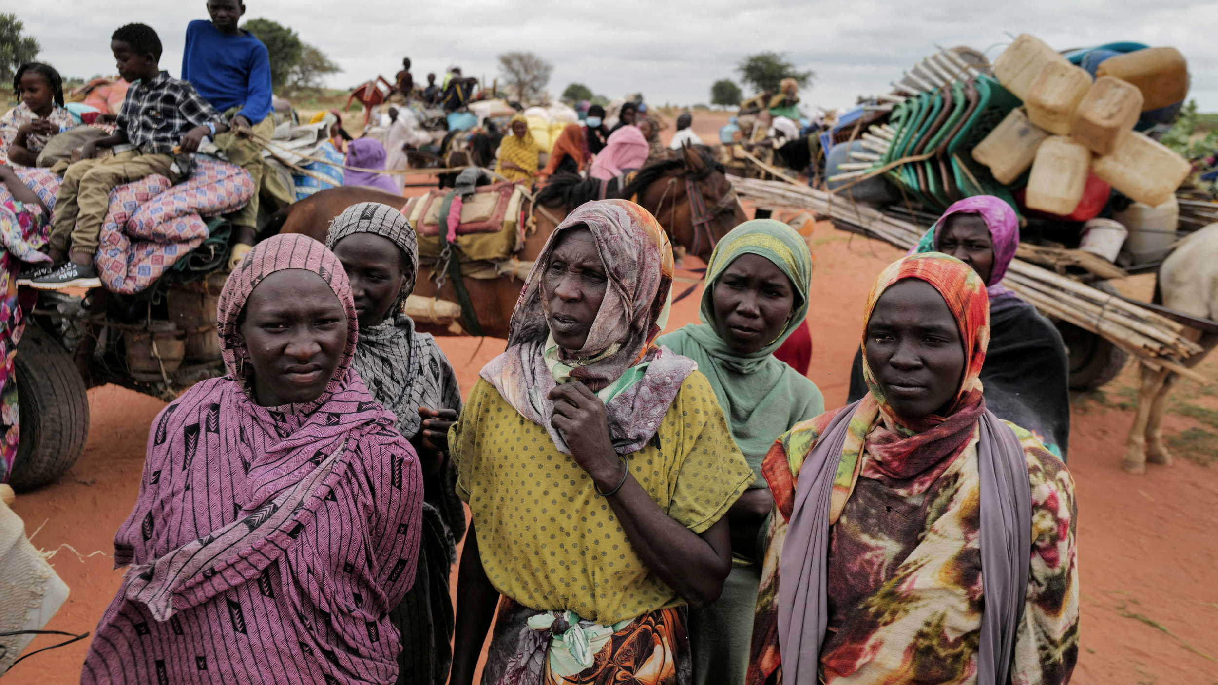 Sudanese women, who fled the conflict in Murnei in Sudan's Darfur region, wait to be registered by UNHCR upon crossing the border between Sudan and Chad on 26 July 2023 (Reuters)