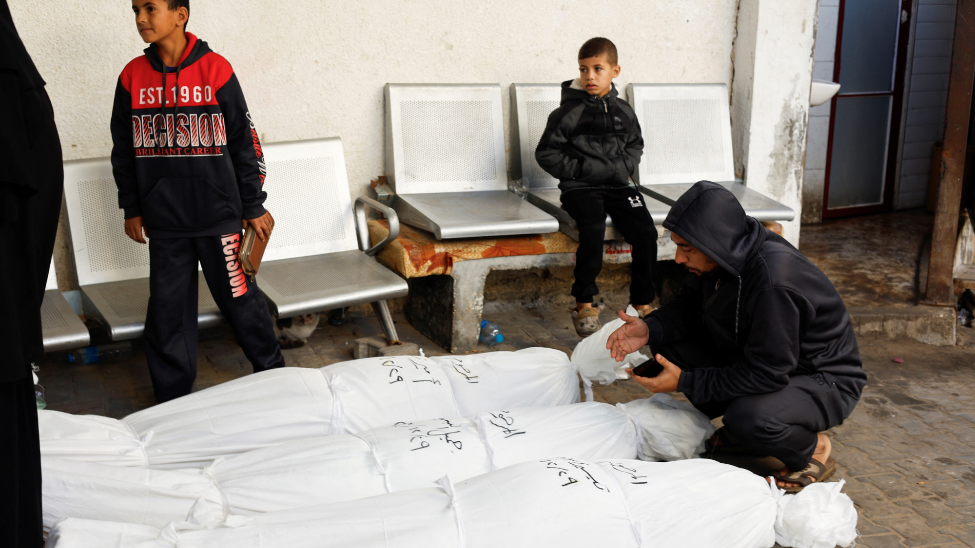 A man prays next to the bodies of Palestinians killed in an Israeli strike at Abu Yousef Al Najjar hospital in Rafah (Mohammed Salem/Reuters)