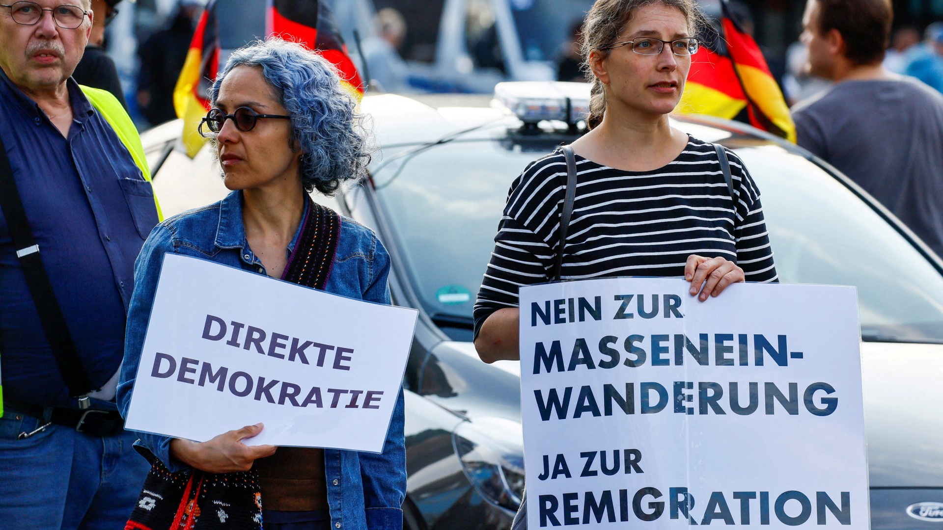 People hold banners that read "Direct democracy" and "No to mass immigration, yes to remigration" as far-right protesters march through the streets of Solingen, following a stabbing rampage in the western German city in which several individuals were killed and injured, in Solingen, Germany, August 26, 2024.