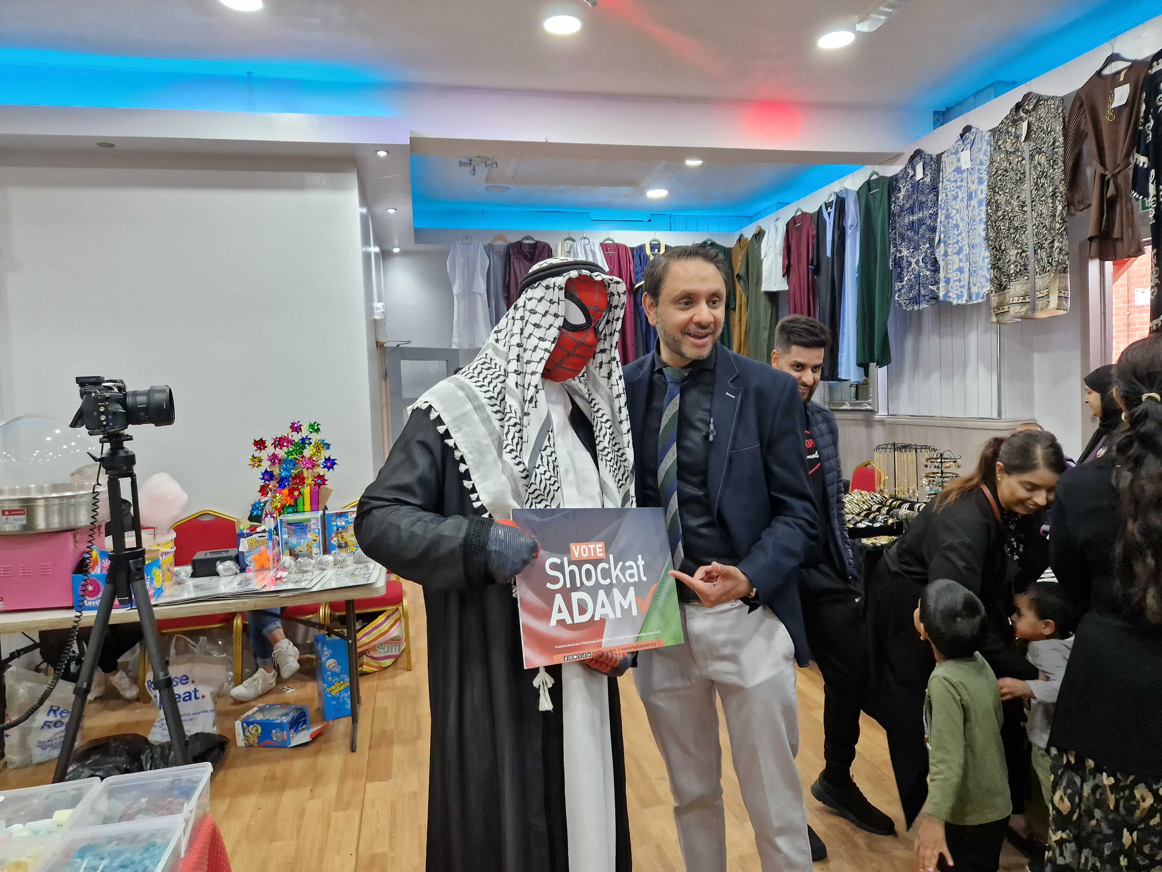 A man dressed as "Arab Spiderman" poses next to Shockat Adam at a charity event