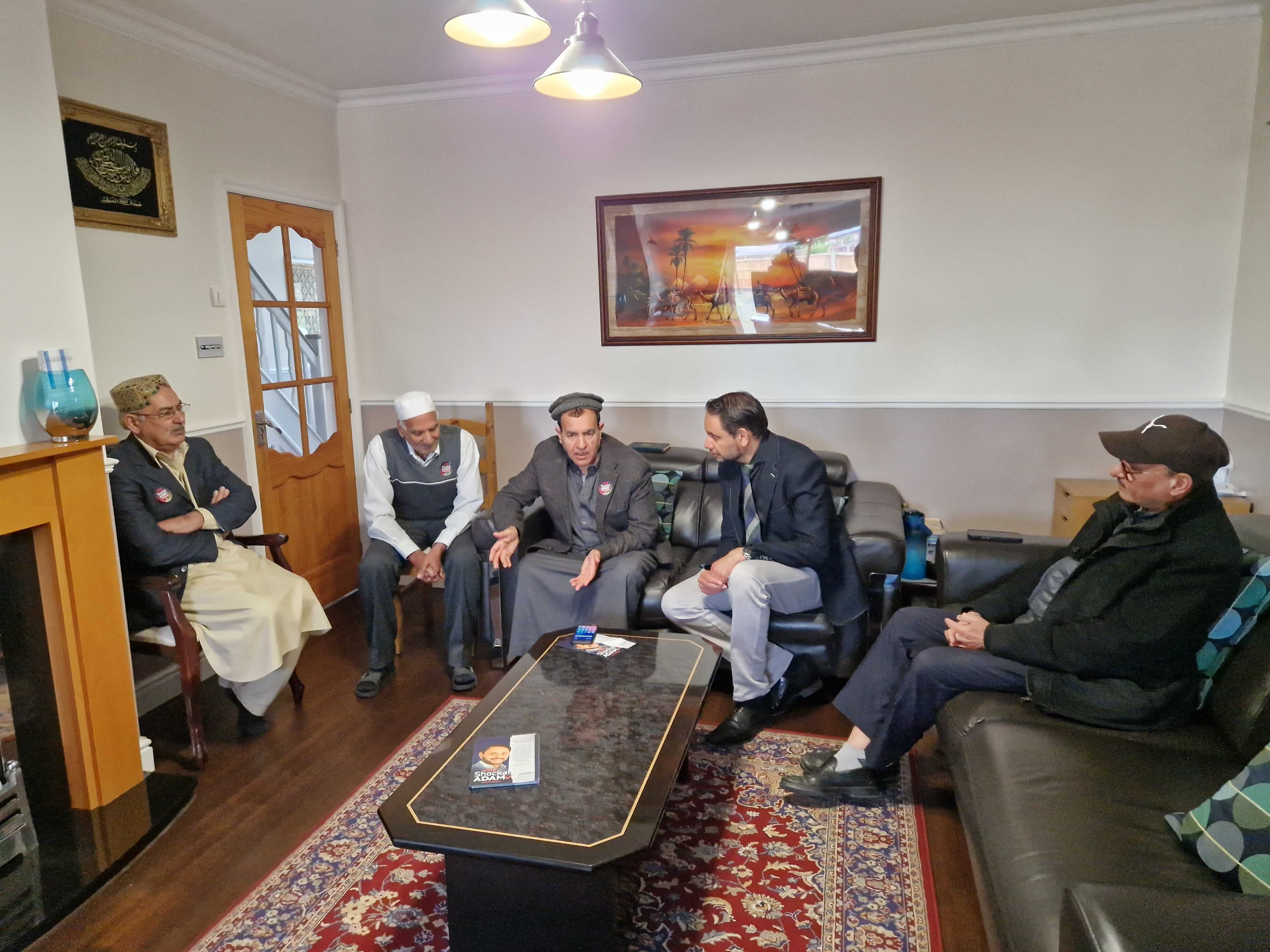 Mohammed Arif, General Secretary of the British Pakistani Association Leicestershire (third from left) talks to candidate Shockat Adam in a meeting of the local British Pakistani community