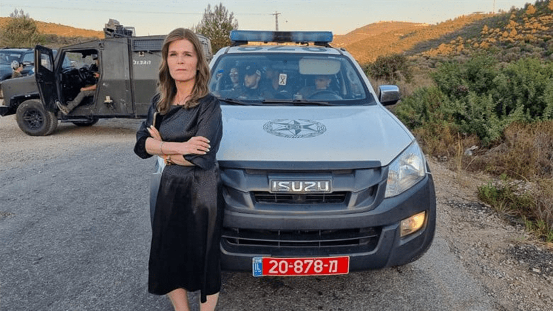 Michal Waldinger stands in front of a police car during an arrest at a settlement, 20 June, 2020 (Twitter)