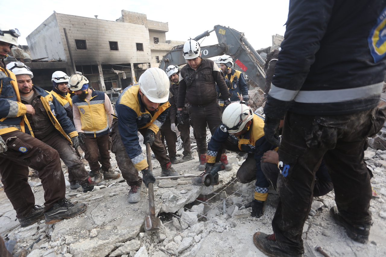 Members of the Civil Defence drag survivors from the rubble of a destroyed home (Ali Haj Suleiman/MEE)