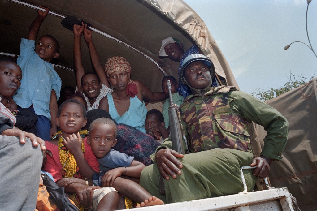 A Ghanaian UN soldier with Tutsi people fleeing the ethnic violence on 13 June 1994 as they are evacuated from Kigali (Abdelhak Senna/AFP)