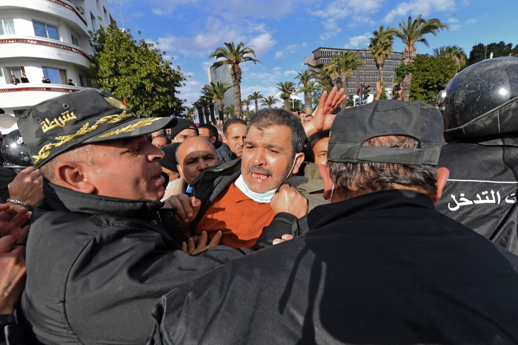 Demonstrators clash with police during protests against President Kais Saied, on the 11th anniversary of the Tunisian revolution in the capital Tunis, 14 January 2022 (AFP)