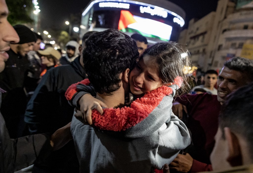 A girl hugs a newly released Palestinian prisoner in Ramallah in the occupied West Bank on 26 November 2023 (AFP)