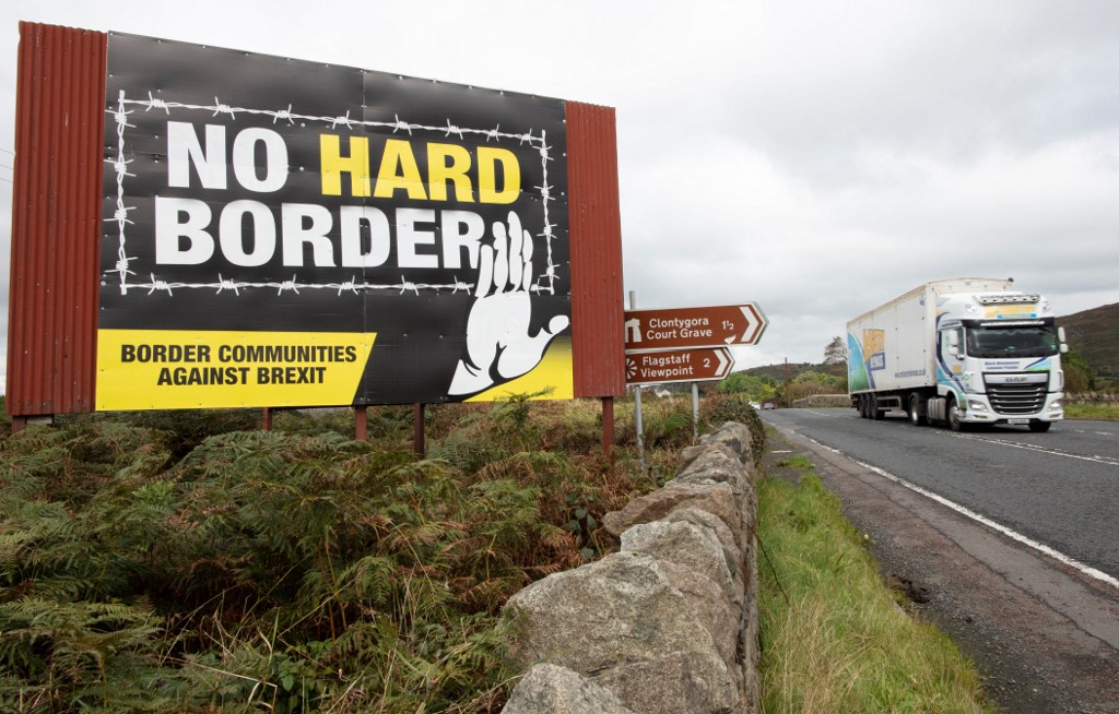 A vehicle passes an anti-Brexit, pro-Irish unity billboard on the border between Newry in Northern Ireland and Dundalk in the Irish Republic, 1 October 2019 (AFP)