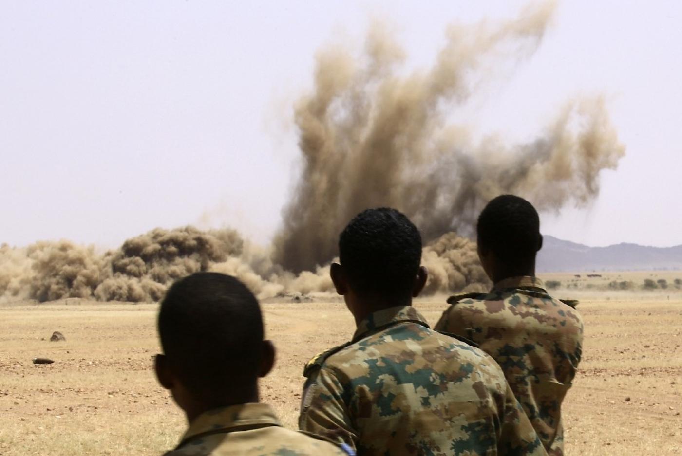 Members of the Sudanese army stand as weapons that were collected from Sudanese citizens are destroyed in the Hajar al-Asal base, the Nile River State north of the capital Khartoum, 29 September (AFP)