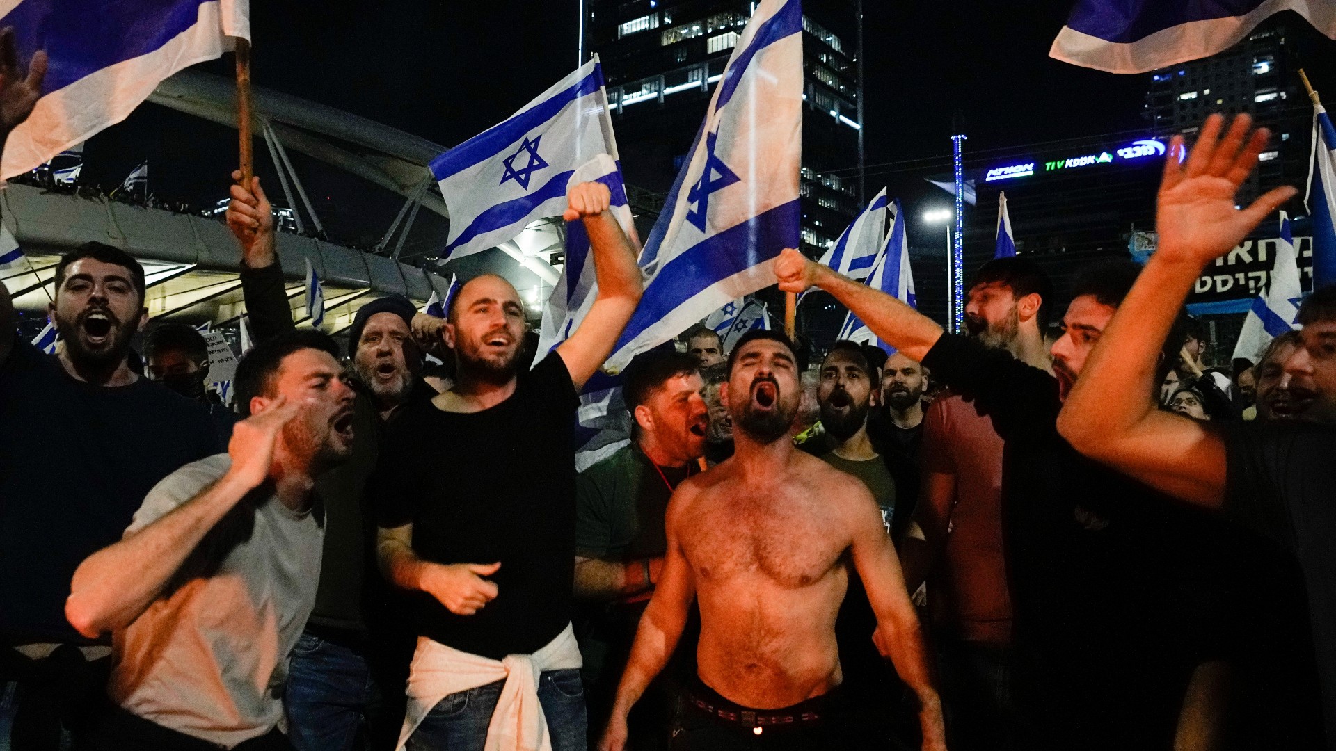 Israelis block a highway during a protest moments after the Israeli leader fired his defence minister, in Tel Aviv (AP)