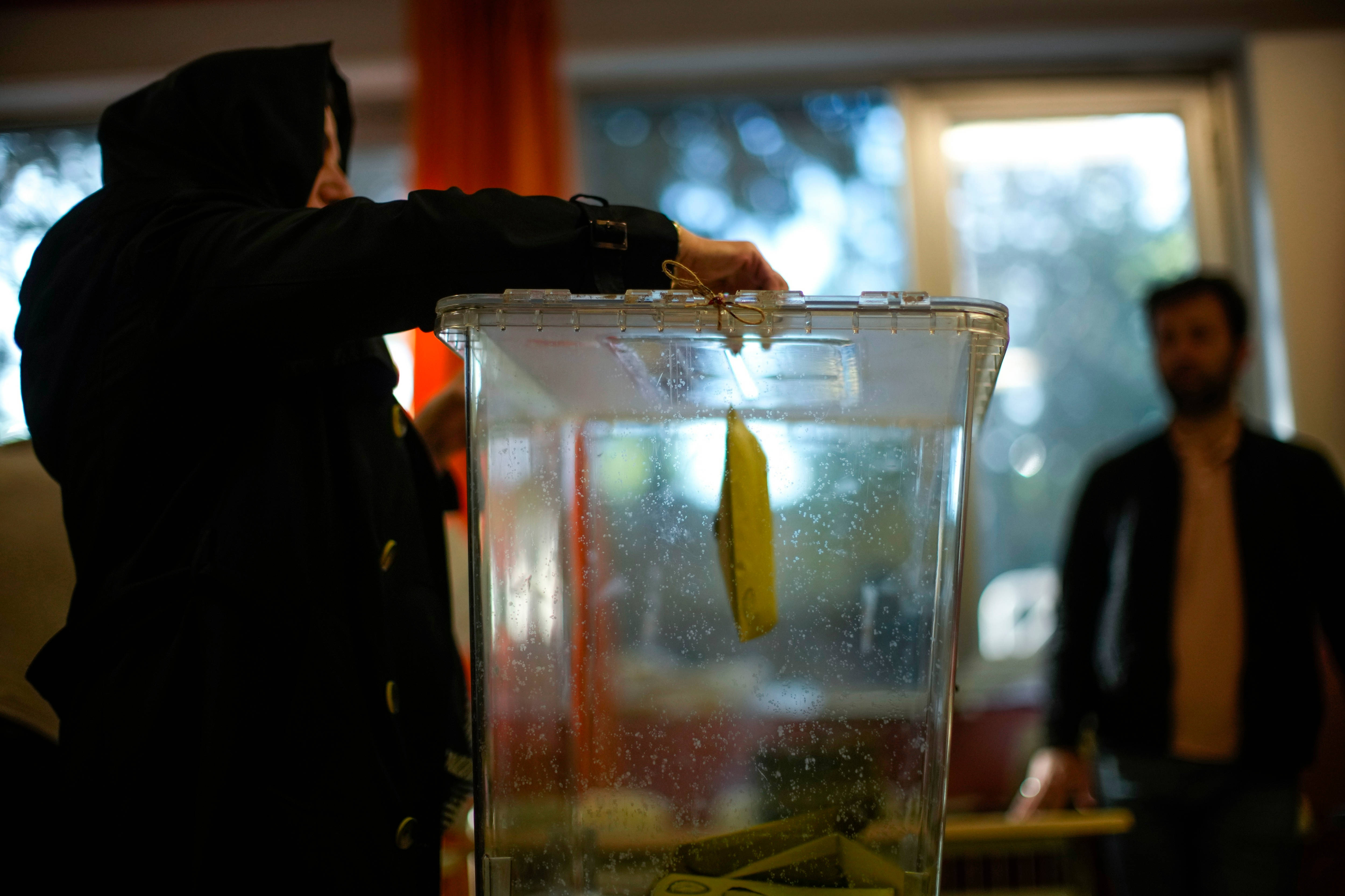 A woman votes at a polling station in Istanbul, Turkey, 14 May 2023 (AP)