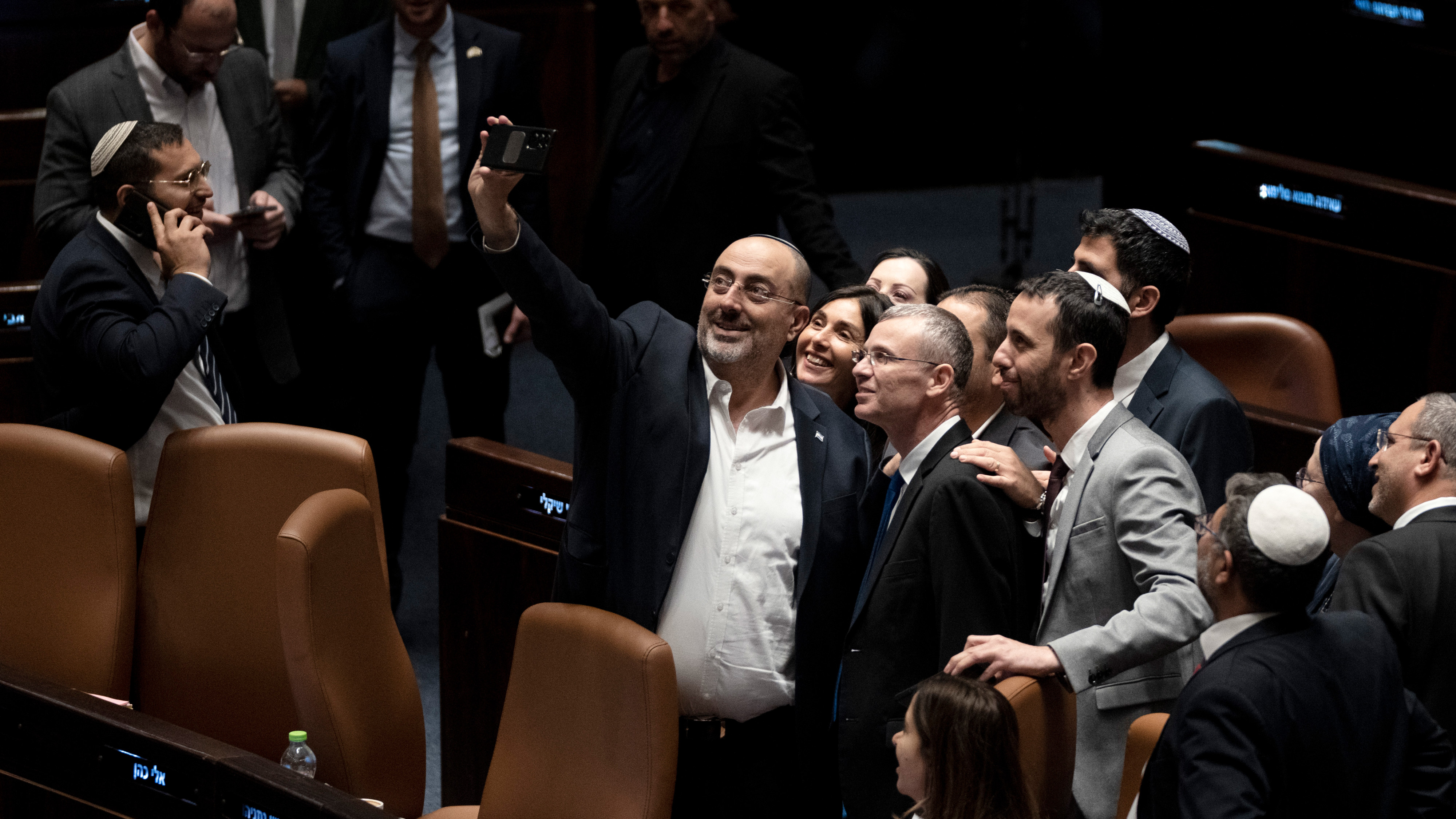 Israeli MPs celebrate and take a selfie with Minister of Justice Yariv Levin after cancelling the reasonableness standard in parliament on 24 July 2023 (AP)