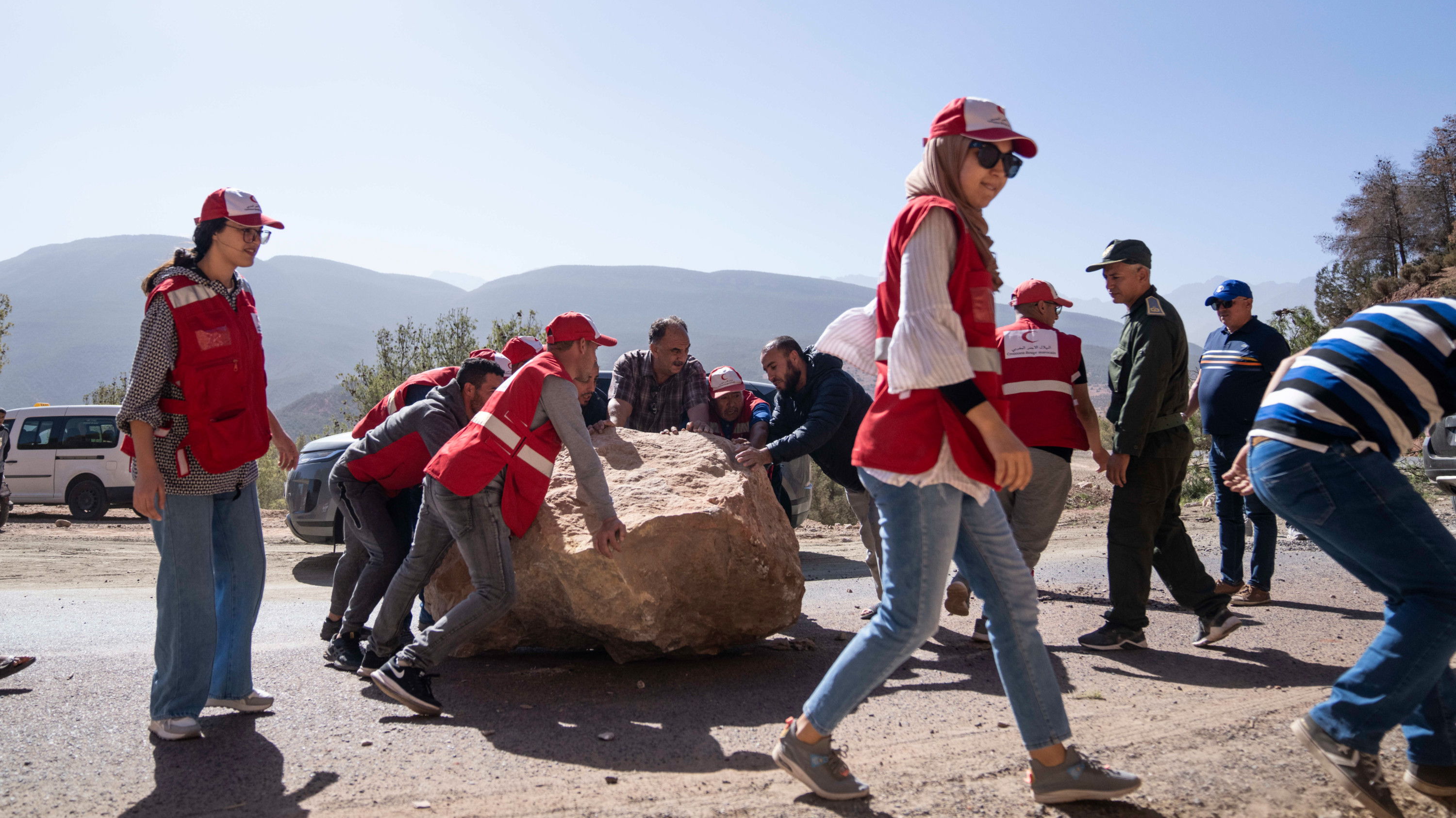 Moroccan Red Crescent workers attempt to remove large stones which fell on roads during an earthquake, on the way to affected villages in the Middle Atlas mountain near Marrakech (AP)