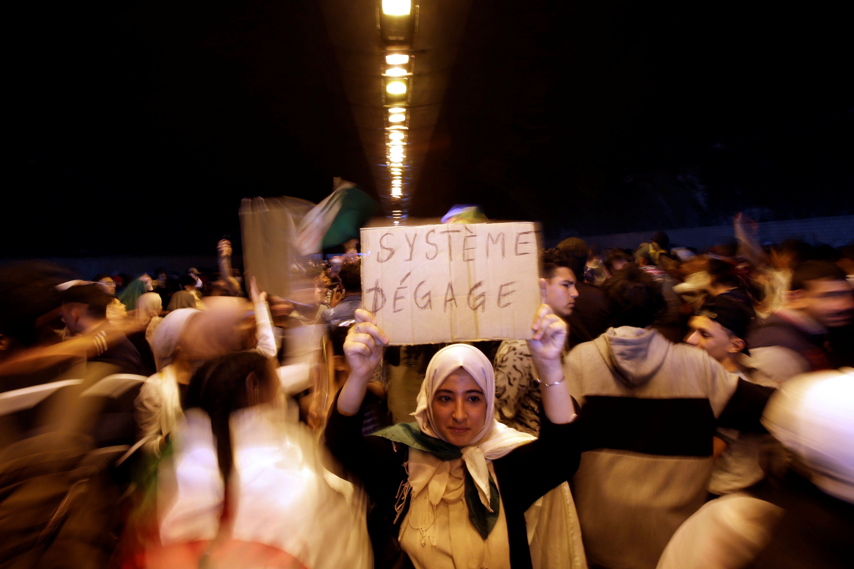 A demonstrator in Algiers holds a sign reading 'Out with the system' (Reuters/File photo)