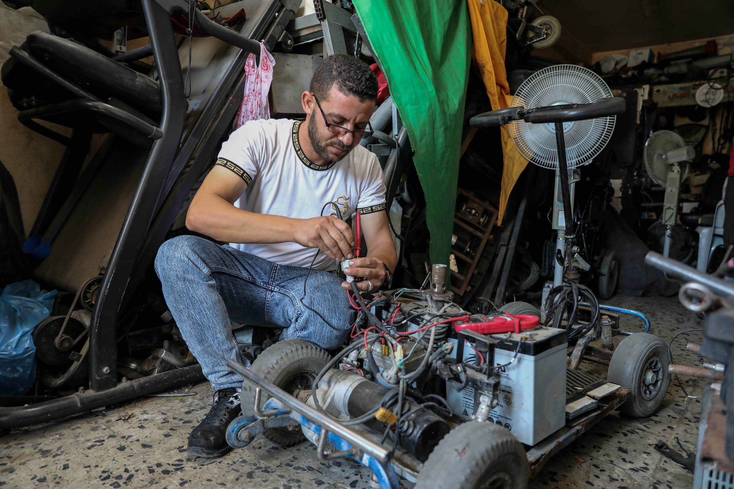 Ali al-Hindi repairs a scooter in his workshop