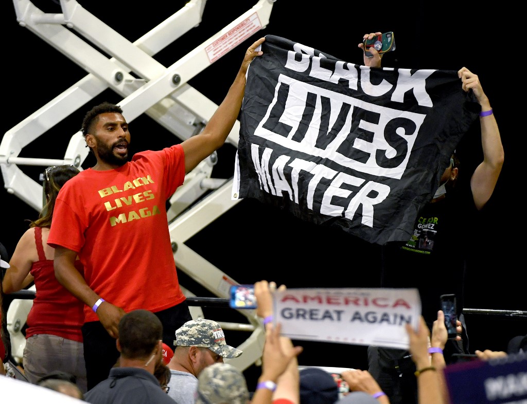 Protesters hold up a Black Lives Matter banner during a Trump campaign event in Nevada on 13 September (AFP)