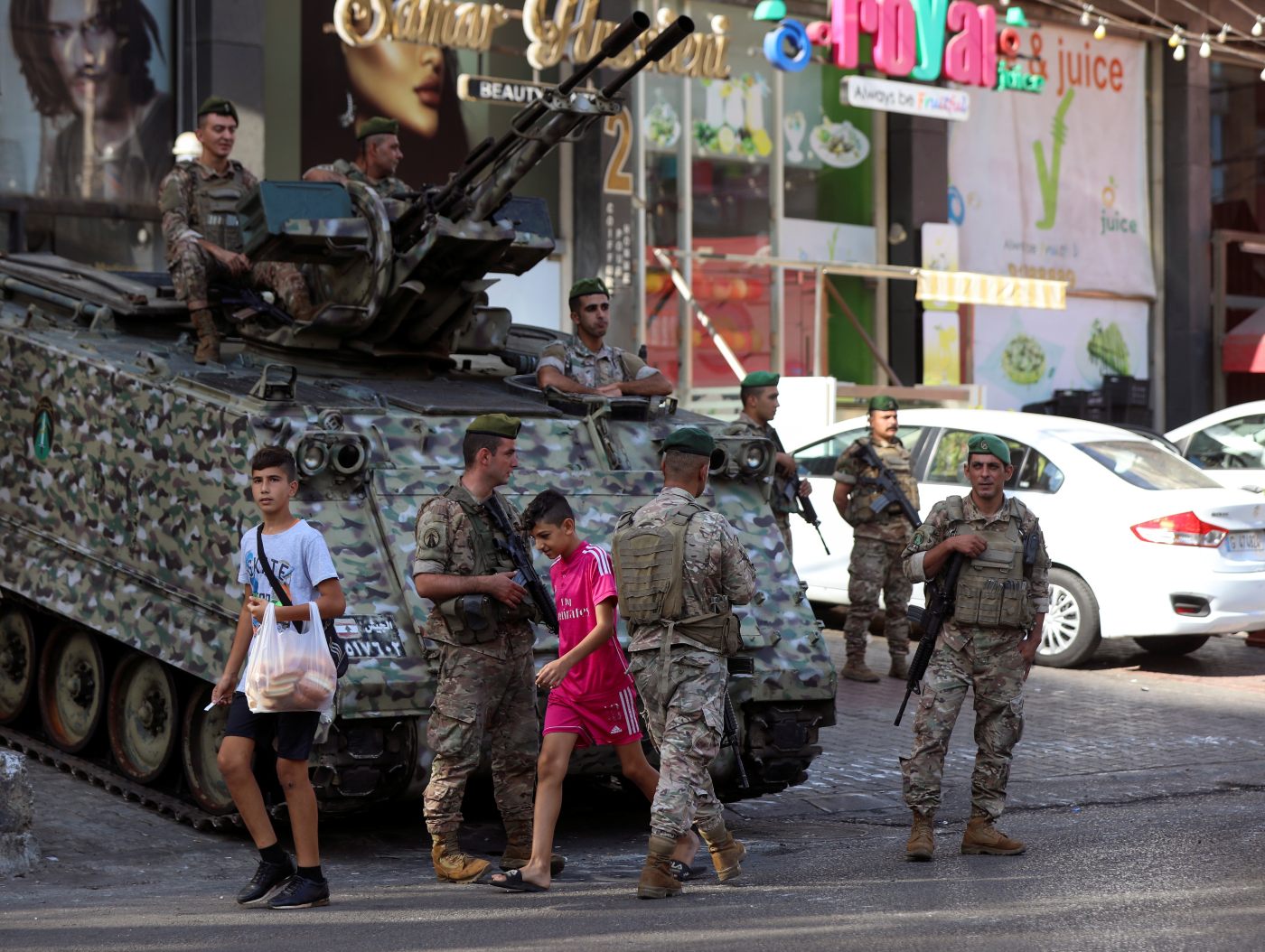 Boys walk past Lebanese army soldiers in Beirut, Lebanon on 15 October 2021, a day after gunfire erupted (Reuters)