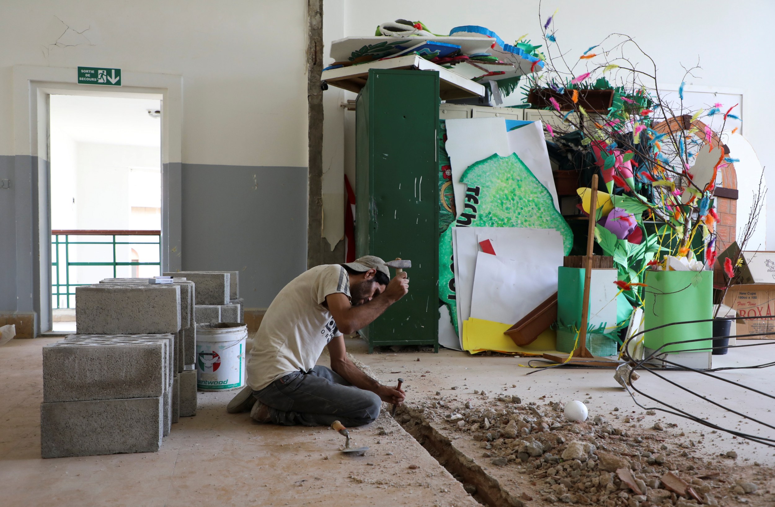 A man works on repairs inside Sagesse Beyrouth school on 24 September 2020, which was damaged due to the explosion at the Beirut port on 4 August 2020. (Reuters)