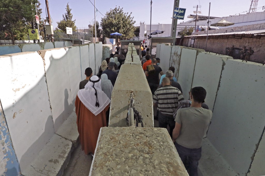 Palestinians queue at the Bethlehem checkpoint in the occupied West Bank on 30 April 2021 (AFP)