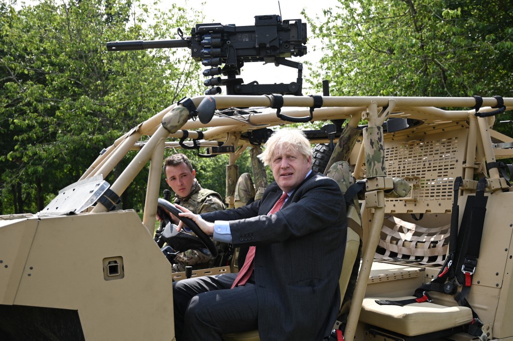 Britain's Prime Minister Boris Johnson poses in an armoured vehicle in Aldershot, southwest England, 24 June 2021