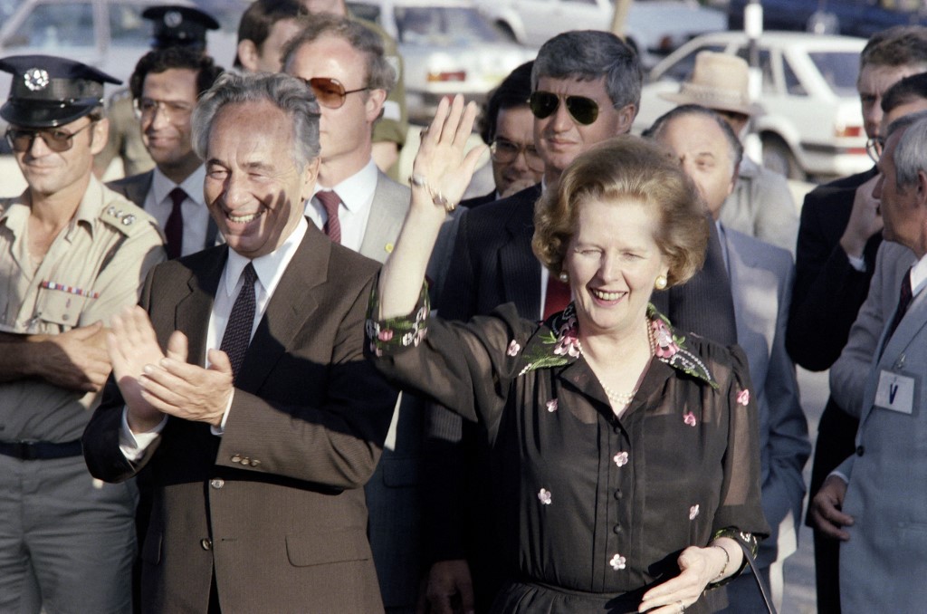 British Prime Minister Margaret Thatcher salutes as Israeli Prime Minister Shimon Peres applauds on 25 May 1986 in Jerusalem, during her four-day visit to Israel (AFP)