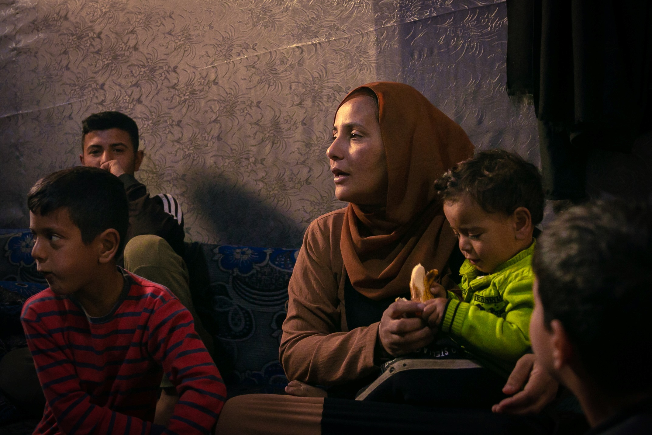 Khawla Hassan est entourée de ses enfants dans la tente familiale, dans un camp de réfugiés à proximité de Bar Elias (MEE/Philippe Pernot)