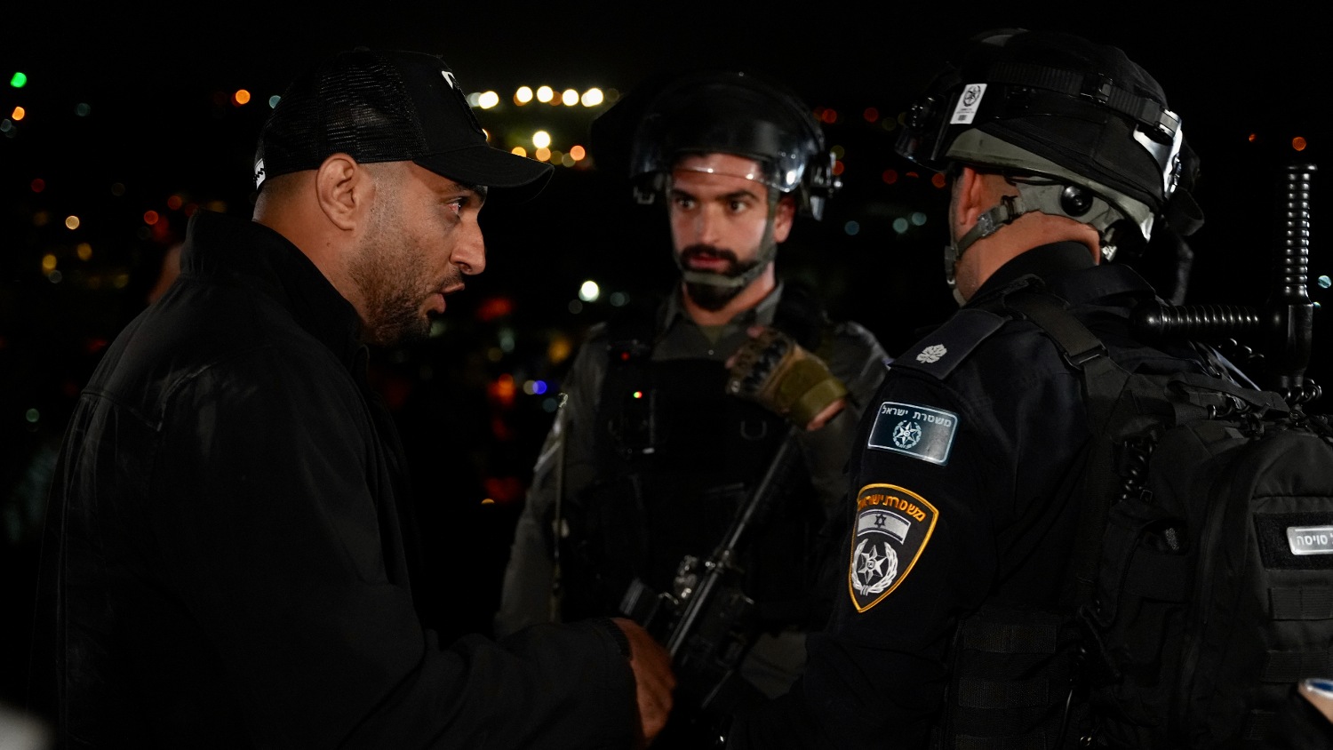 Israeli security forces speak to each other outside the home of Palestinian prisoner Israa Jaabis.