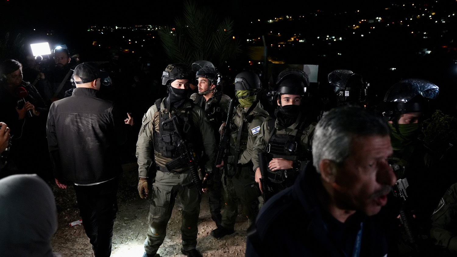 Israeli security forces stand outside the home of Palestinian prisoner Israa Jaabis.