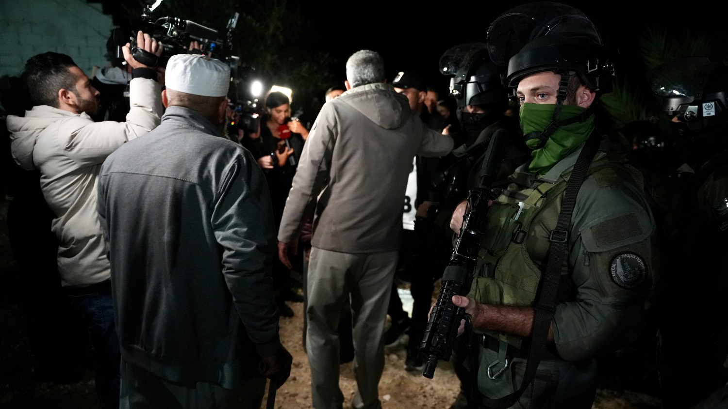 A member of Israel's security forces stands outside the home of Palestinian prisoner Israa Jaabis.