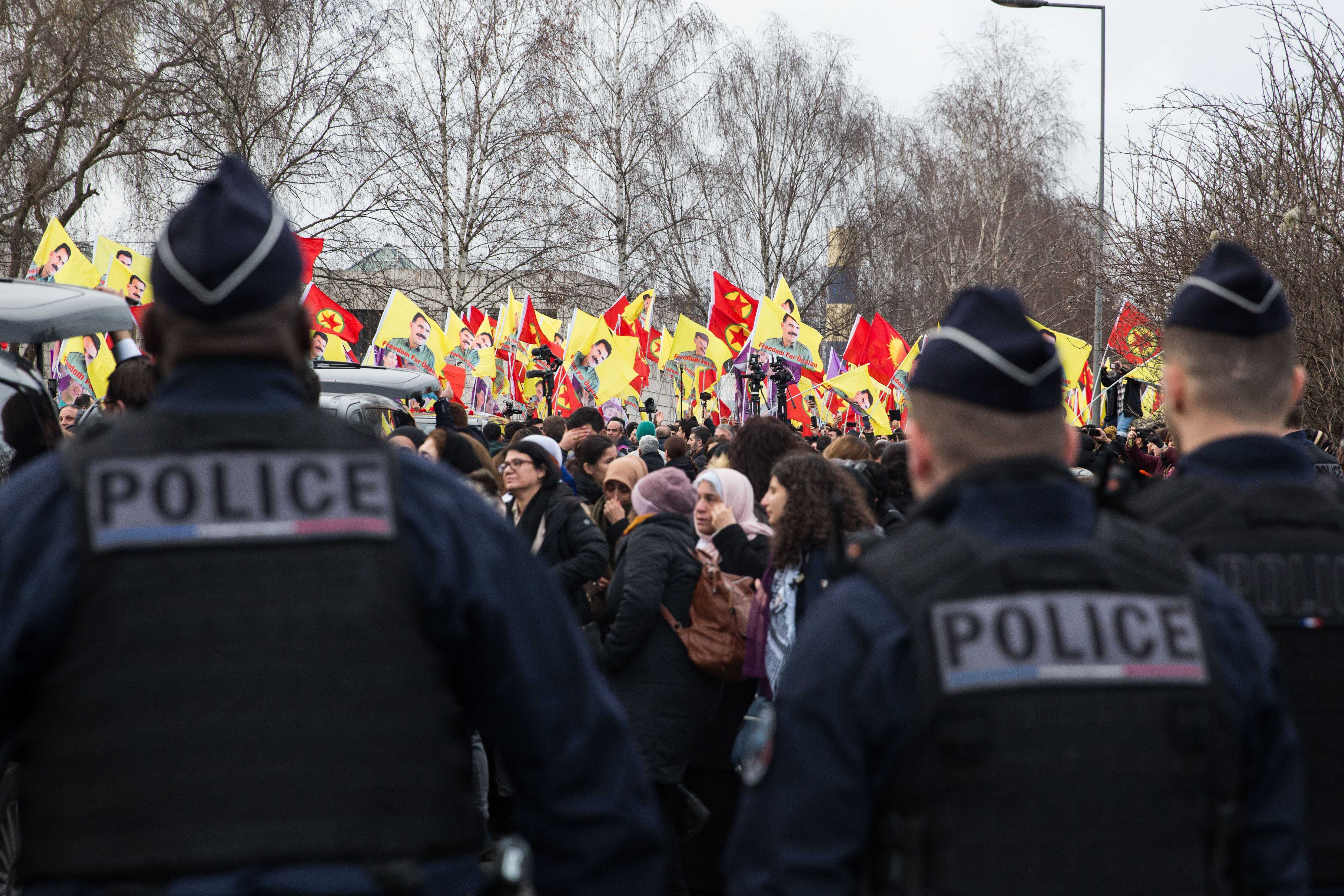 Police watch members of Europe's Kurdish community outside the funeral service in northern Paris on 3 January 2023 (Laurent Perpigna Iban/MEE)