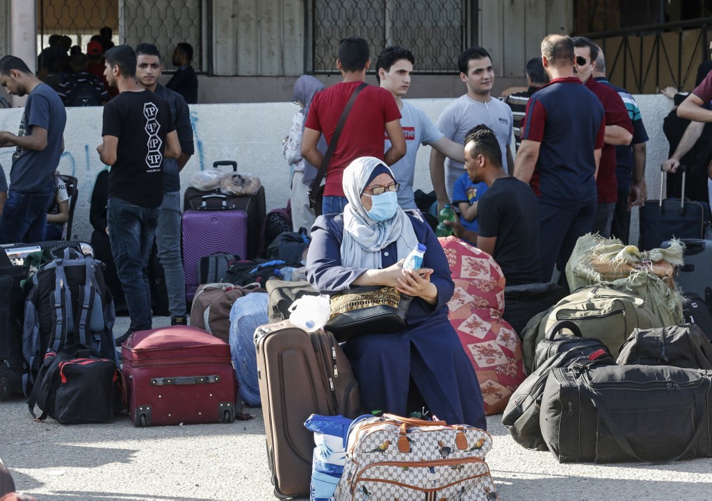 Des Palestiniens attendent de passer du côté égyptien du poste frontalier de Rafah après des mois de fermeture due au coronavirus, dans le sud de la bande de Gaza, le 11 août 2020 (AFP)