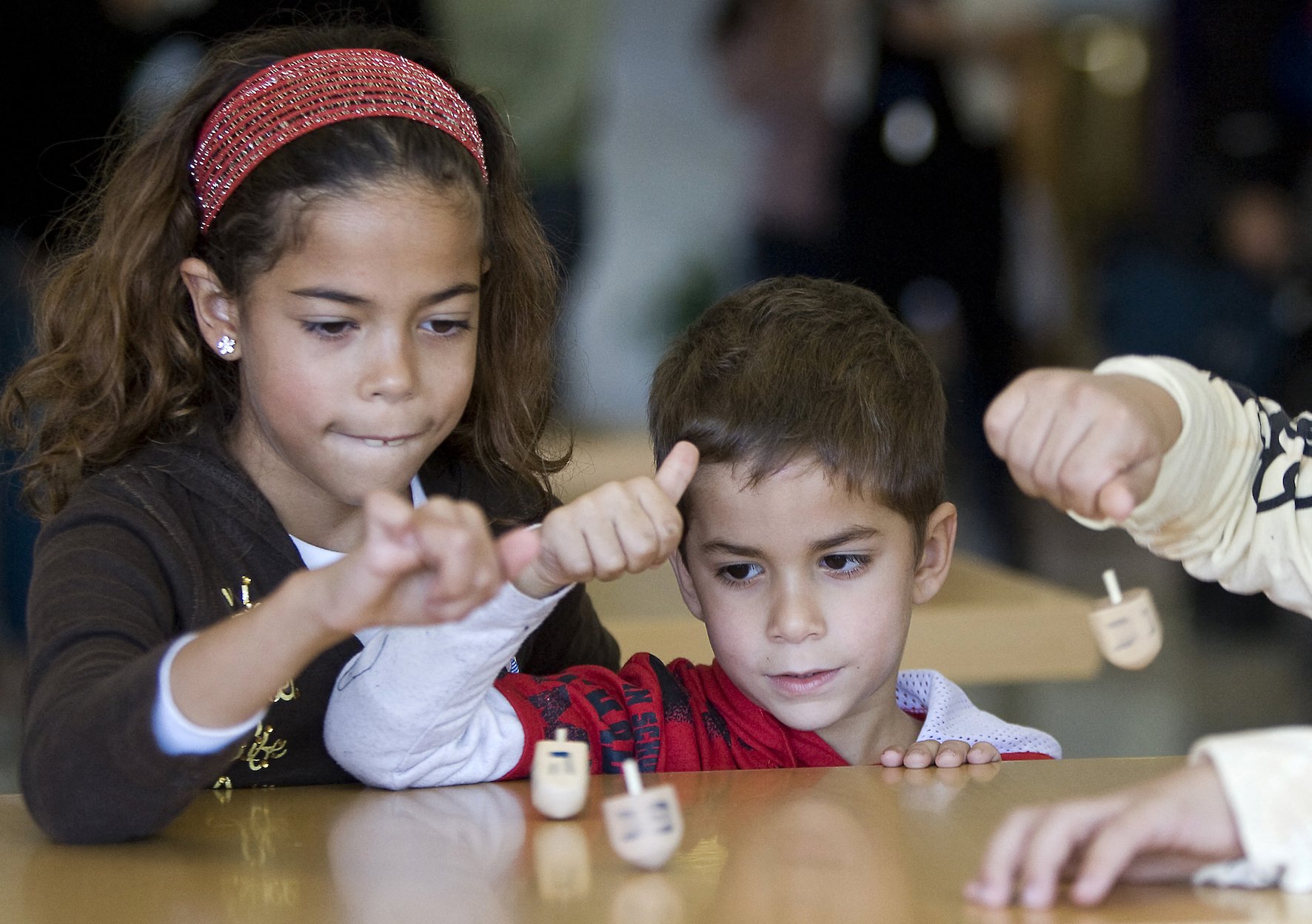 Des enfants juifs jouent avec une dreidel pour les fêtes de Hanoukka à Tel Aviv (AFP/Jonathan Nackstrand)
