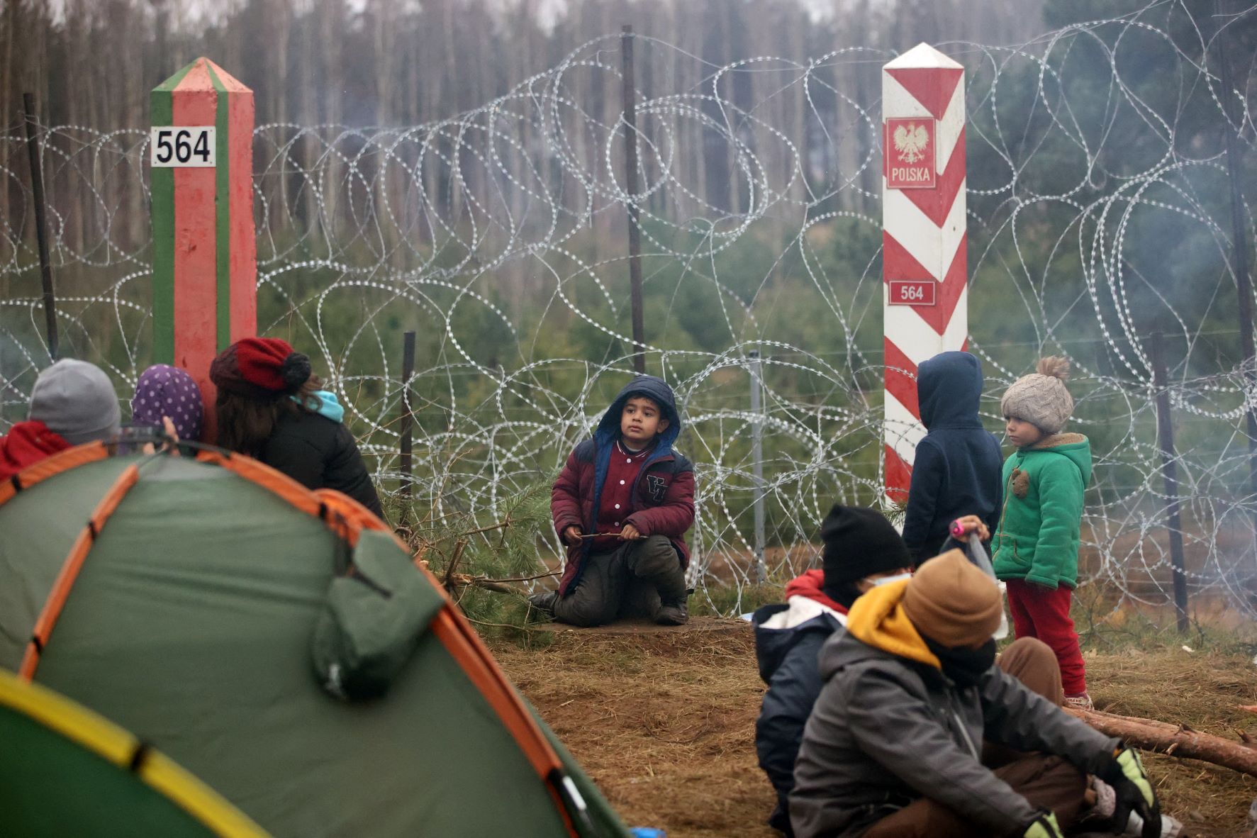 Des enfants se trouvent dans un camp de réfugiés à la frontière entre la Biélorussie et la Pologne, dans la région de Hrodna, le 12 novembre 2021 (AFP)