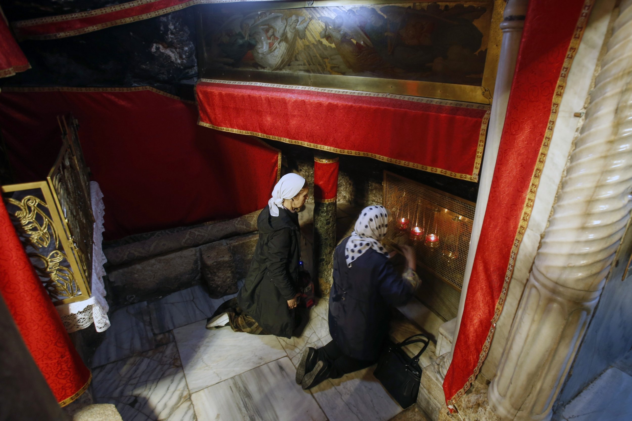 Des pèlerins chrétiens prient à l’église de la Nativité (le lieu où Jésus serait né selon les chrétiens) dans la ville sainte de Bethléem, en Cisjordanie (AFP)