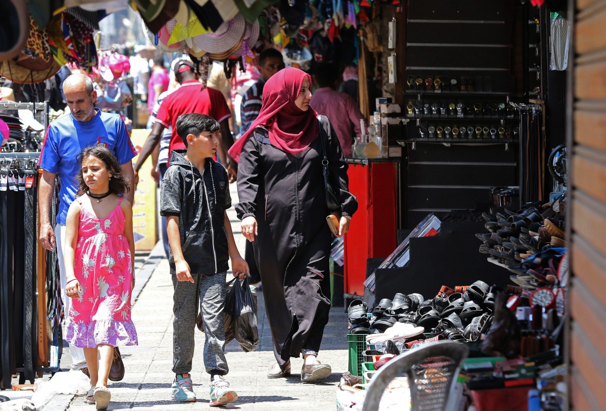People stroll in a traditional market in downtown Amman on June 4, 2018 (AFP)