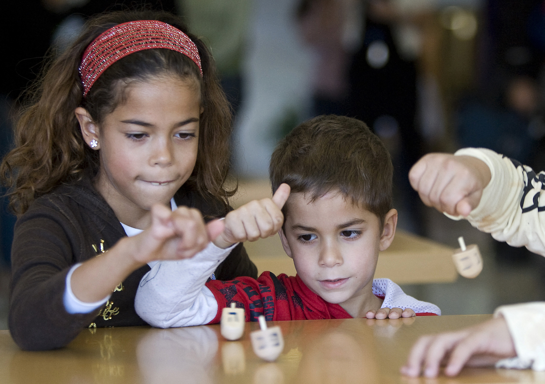 Jewish children play with a Dreidel during Hanukkah celebrations in Tel Aviv (AFP)