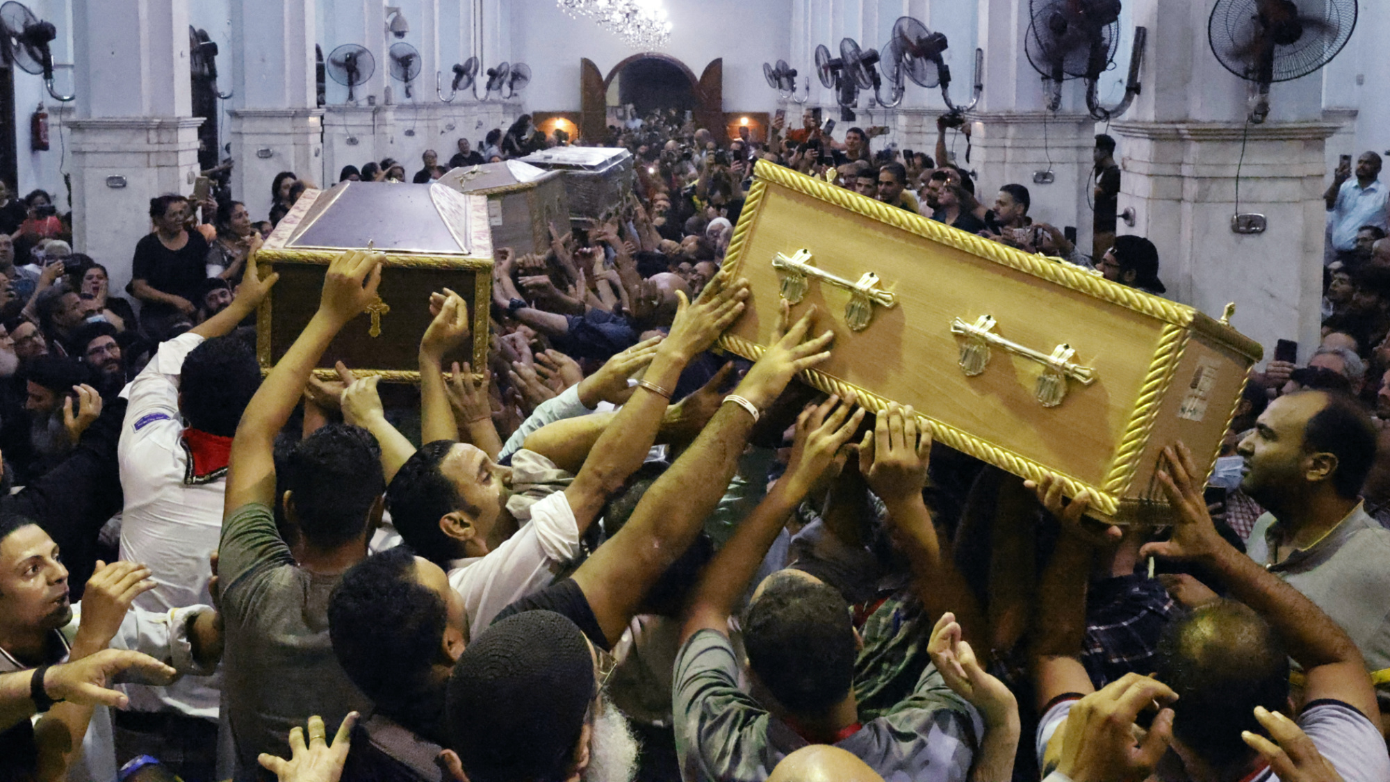 Des Égyptiens en deuil portent le cercueil d’Ibram Tamer Wageh (à droite), un petit garçon tué dans l’incendie d’une église copte du Caire, lors de funérailles à l’église de la Bienheureuse Vierge Marie à Embabeh (AFP)