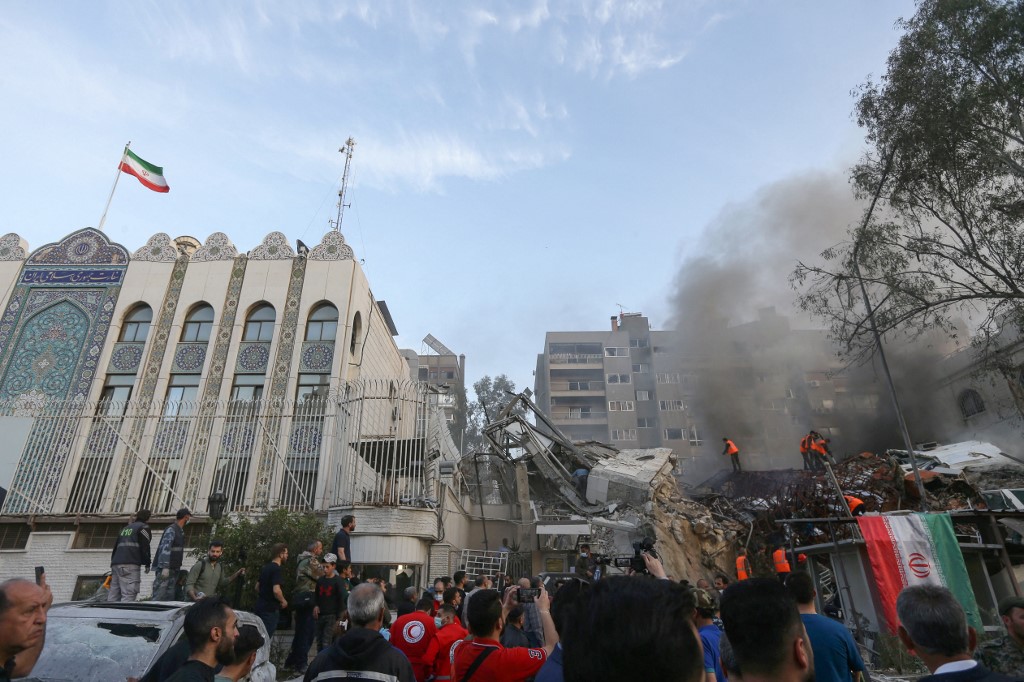 Emergency personnel search the rubble at the site of strikes which hit a building annexed to the Iranian embassy in Syria's capital Damascus, 1 April 2024 (Louai Beshari/AFP)